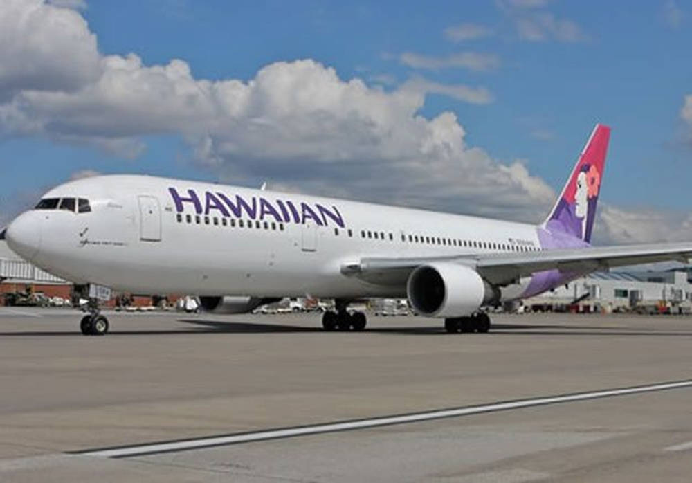 夏威夷航空噴射機停在機場跑道上，藍天白雲