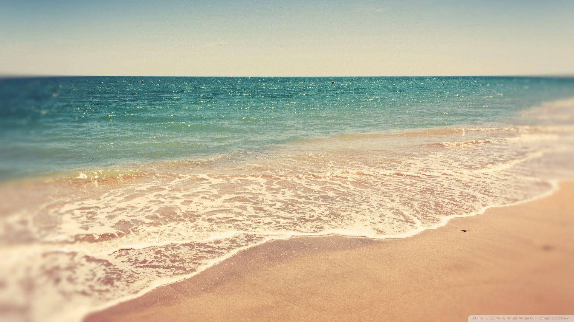 溫和的海浪沖刷著溫暖的沙灘，天空清澈湛藍 — 夏季 壁紙