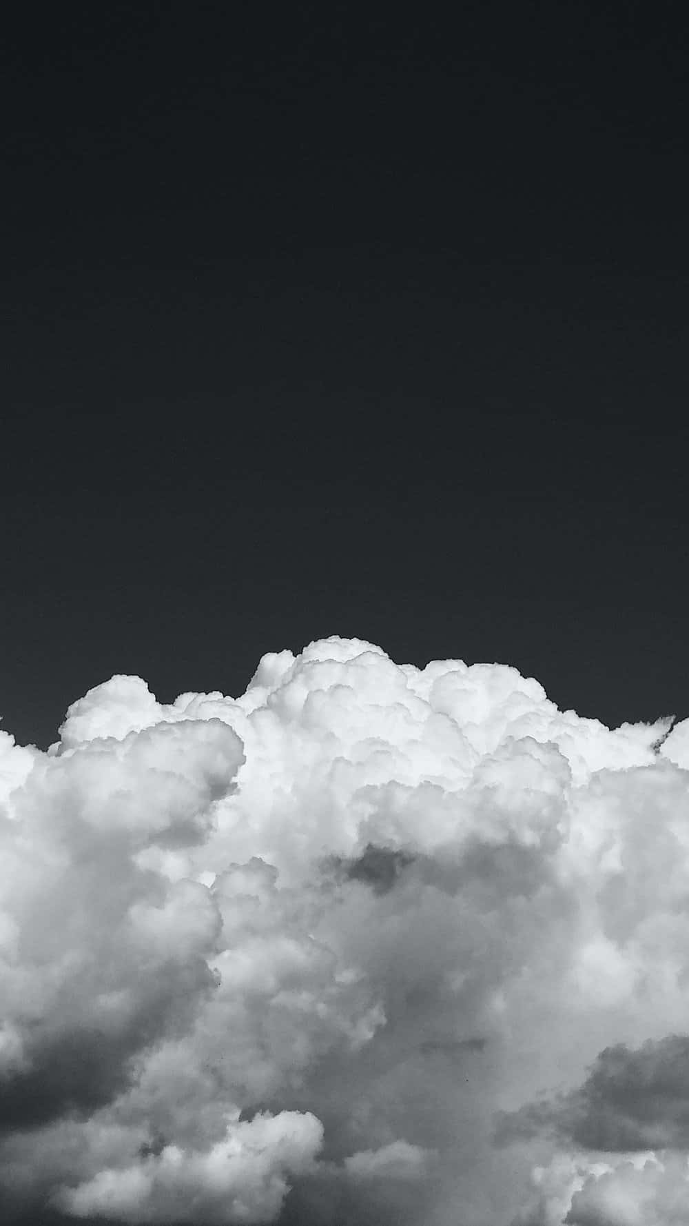 在黑暗天空襯托下，體積感十足的雲朵呈現鮮明的黑白對比。