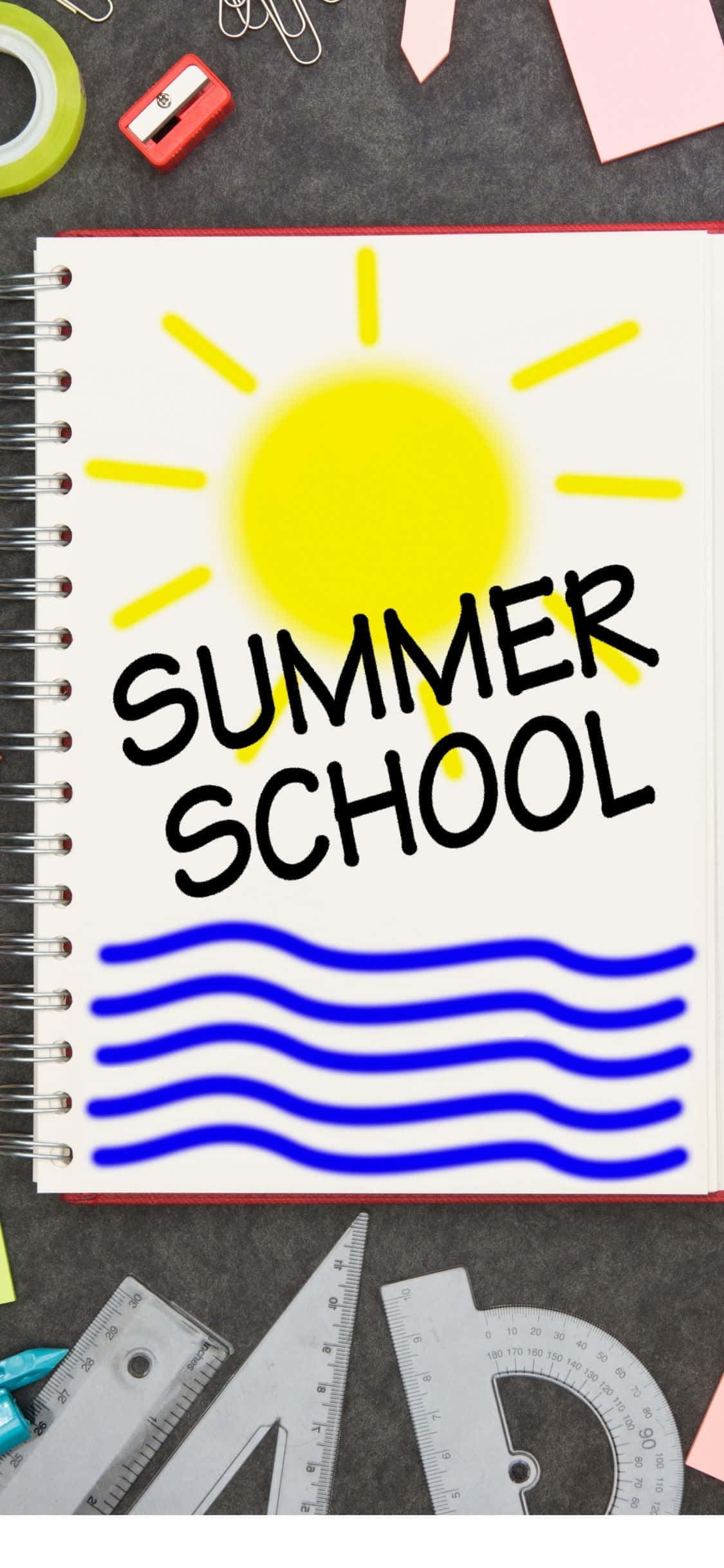夏日課本 iPhone X 夏日背景 壁紙 — 一本螺旋筆記本，上面有「SUMMER SCHOOL」字樣和黃色太陽圖案，放在被學校用品包圍的書桌上。