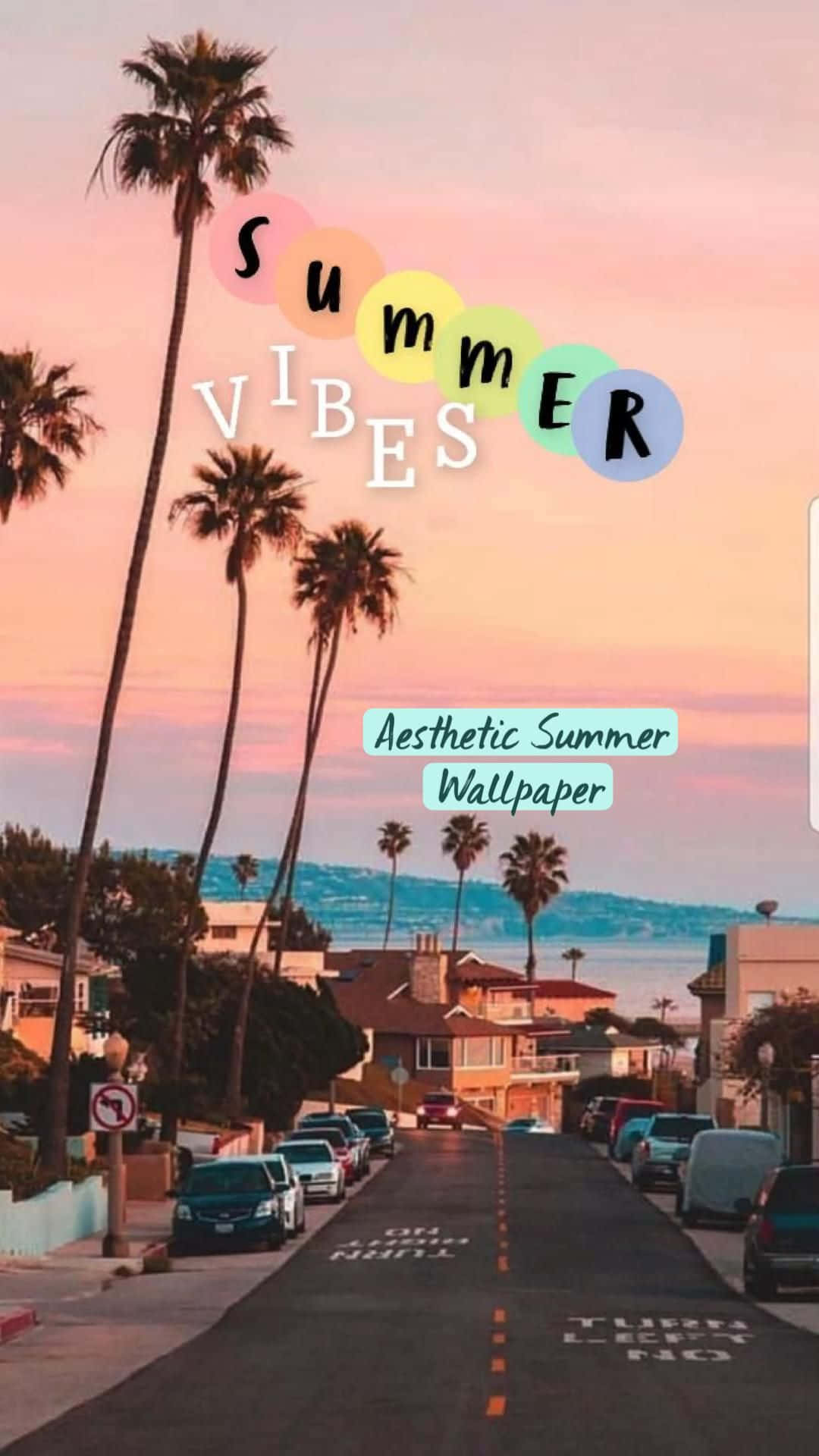 夏日陽光灑落海灘，筆電靜置一旁 壁紙 — 一條陽光普照的海岸街道，兩旁種滿棕櫚樹和粉彩房屋，在粉紅色日落天空下，帶有「summer vibes」文字疊加。