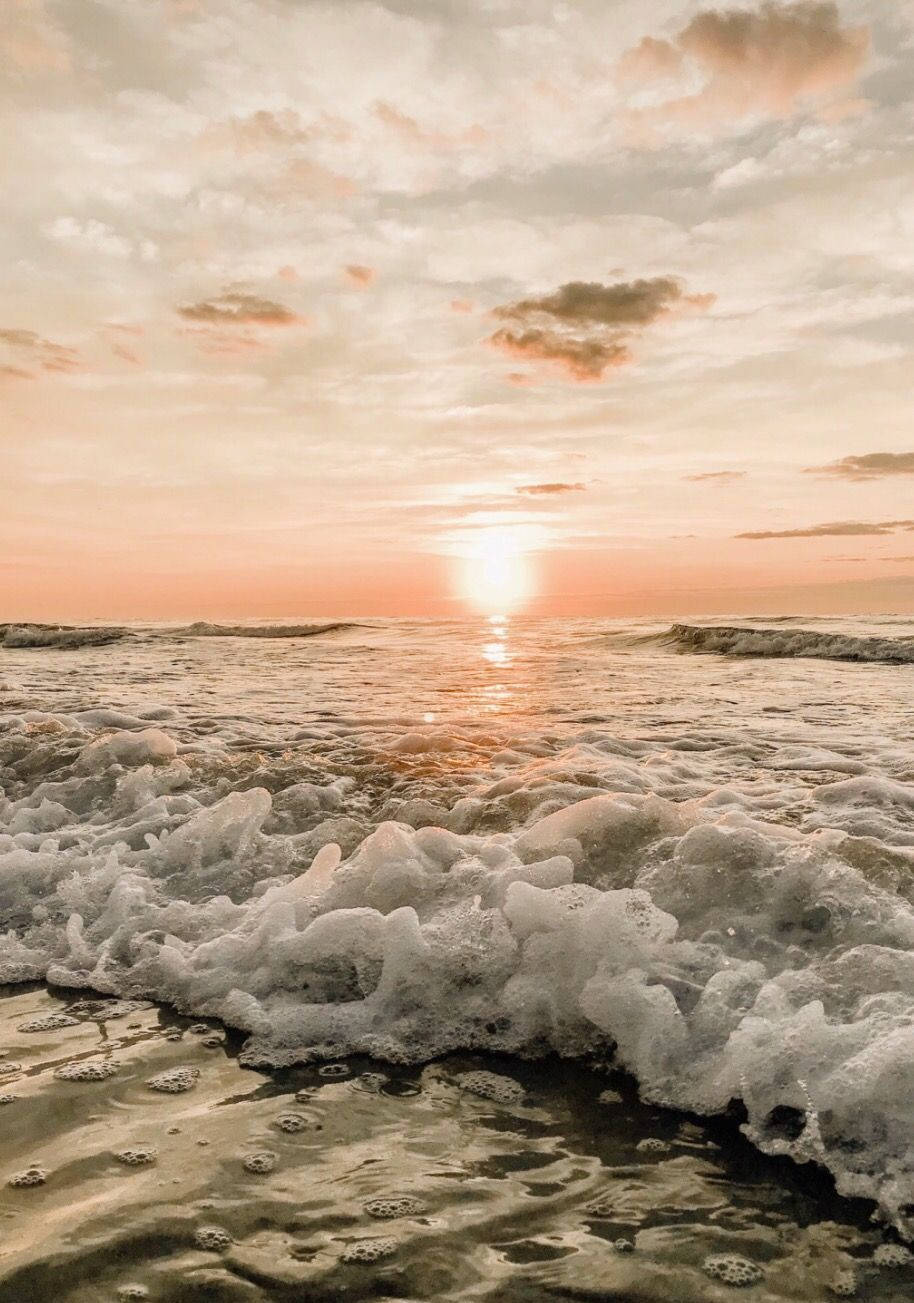 海洋上的夕陽，泡沫海浪湧向沙灘