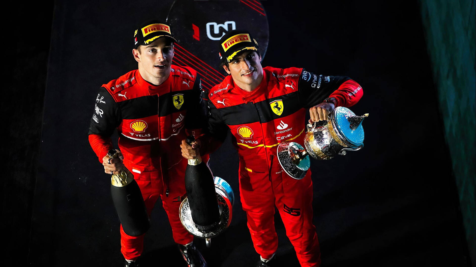 兩名身穿紅色賽車服的F1車手在夜間手持獎盃和香檳瓶。