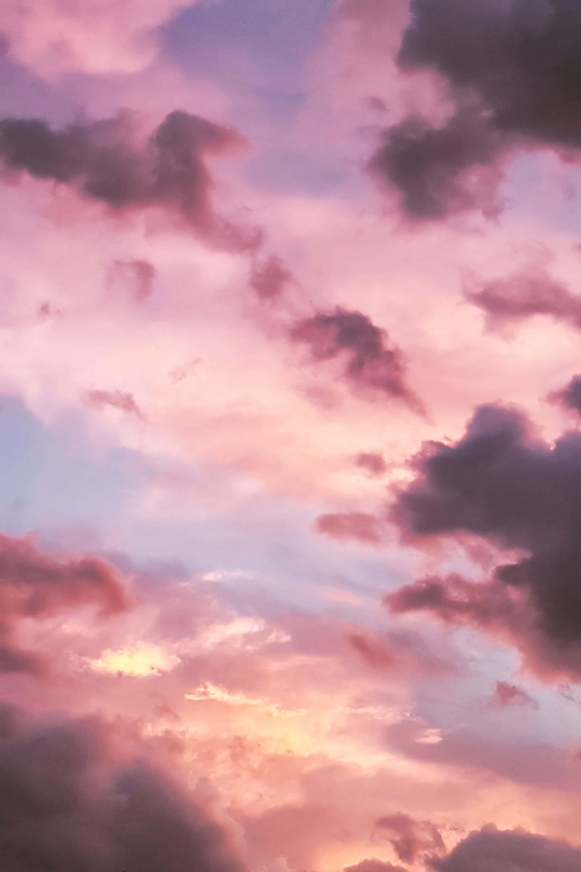 唯美雲朵動態 桌布 壁紙 — 夕陽下，柔和的粉紅色和紫色雲彩閃耀，構成戲劇性的天空。