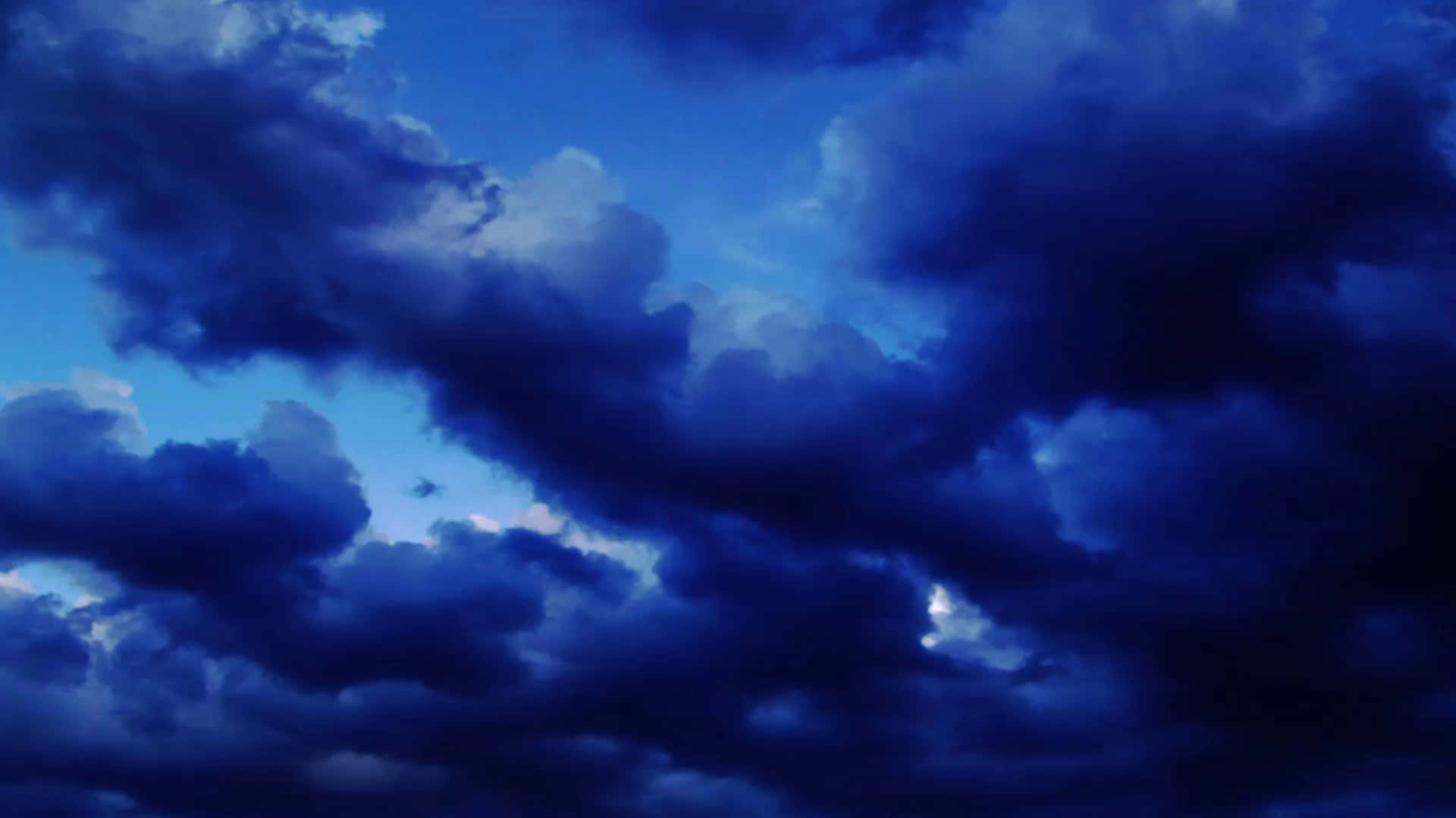 戲劇性的深藍色風暴雲在暮色天空中旋轉。