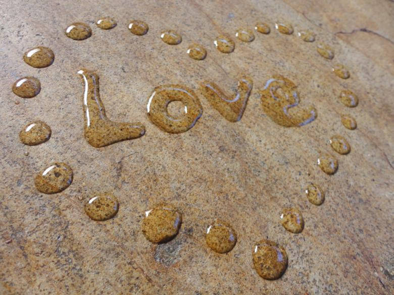 水滴串成 love 並喺石頭表面形成一個心形。