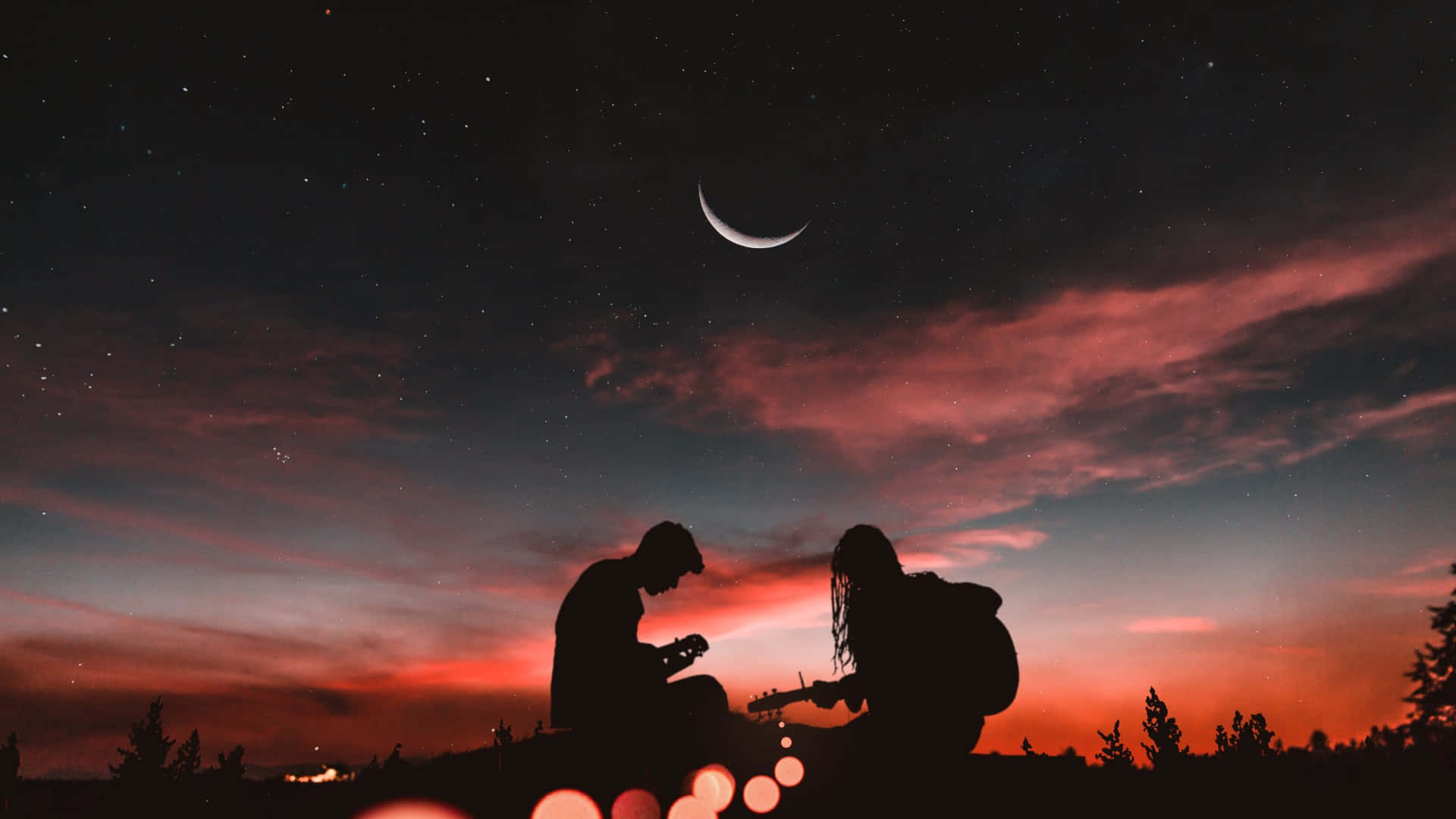 夕陽下浪漫吉他剪影 壁紙 — 兩個剪影音樂家在暮色中的新月和星空下彈結他。