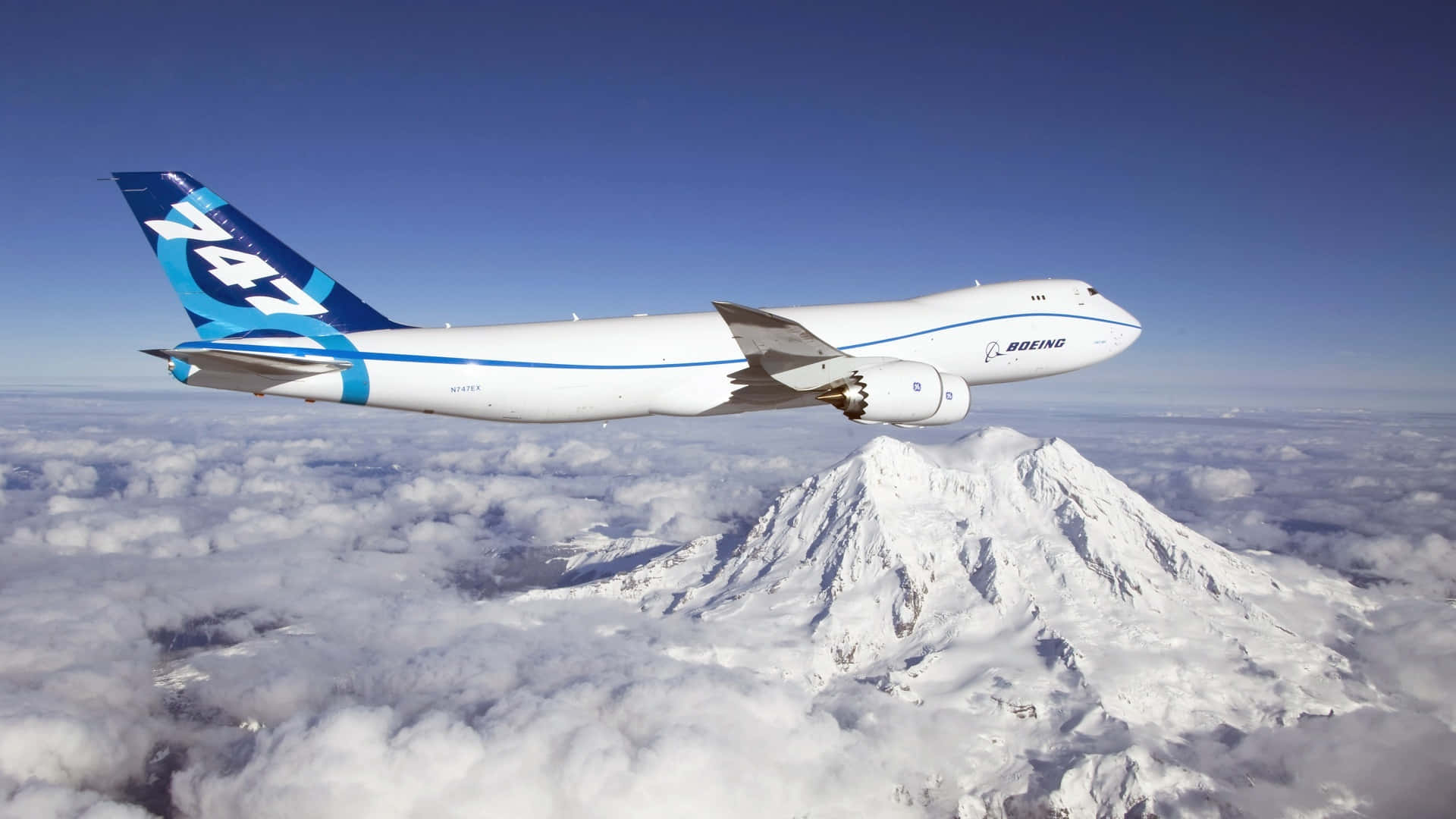 一架波音747飛機在雲層上方飛行，下方有一座積雪的山。