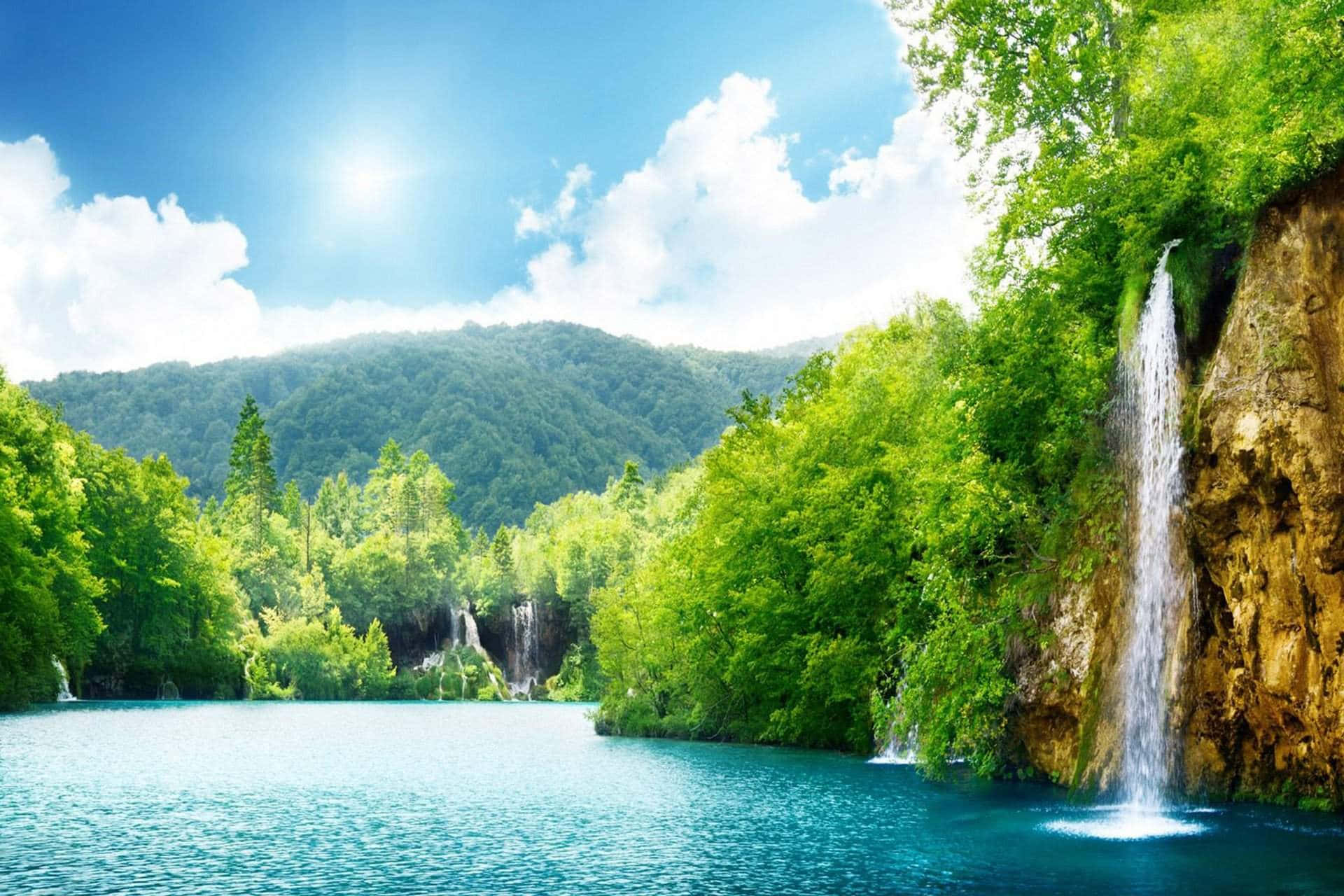 一個寧靜的湖泊，瀑布流經森林覆蓋的山谷，在陽光明媚的天空下。