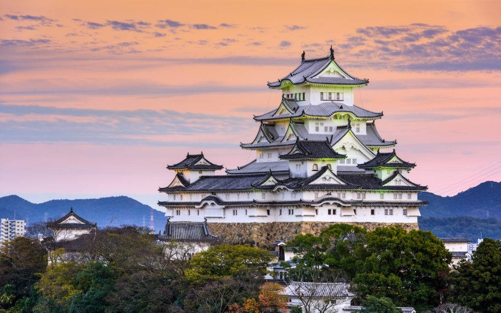 夕陽下的傳統日本城堡，粉紅和橙色天空