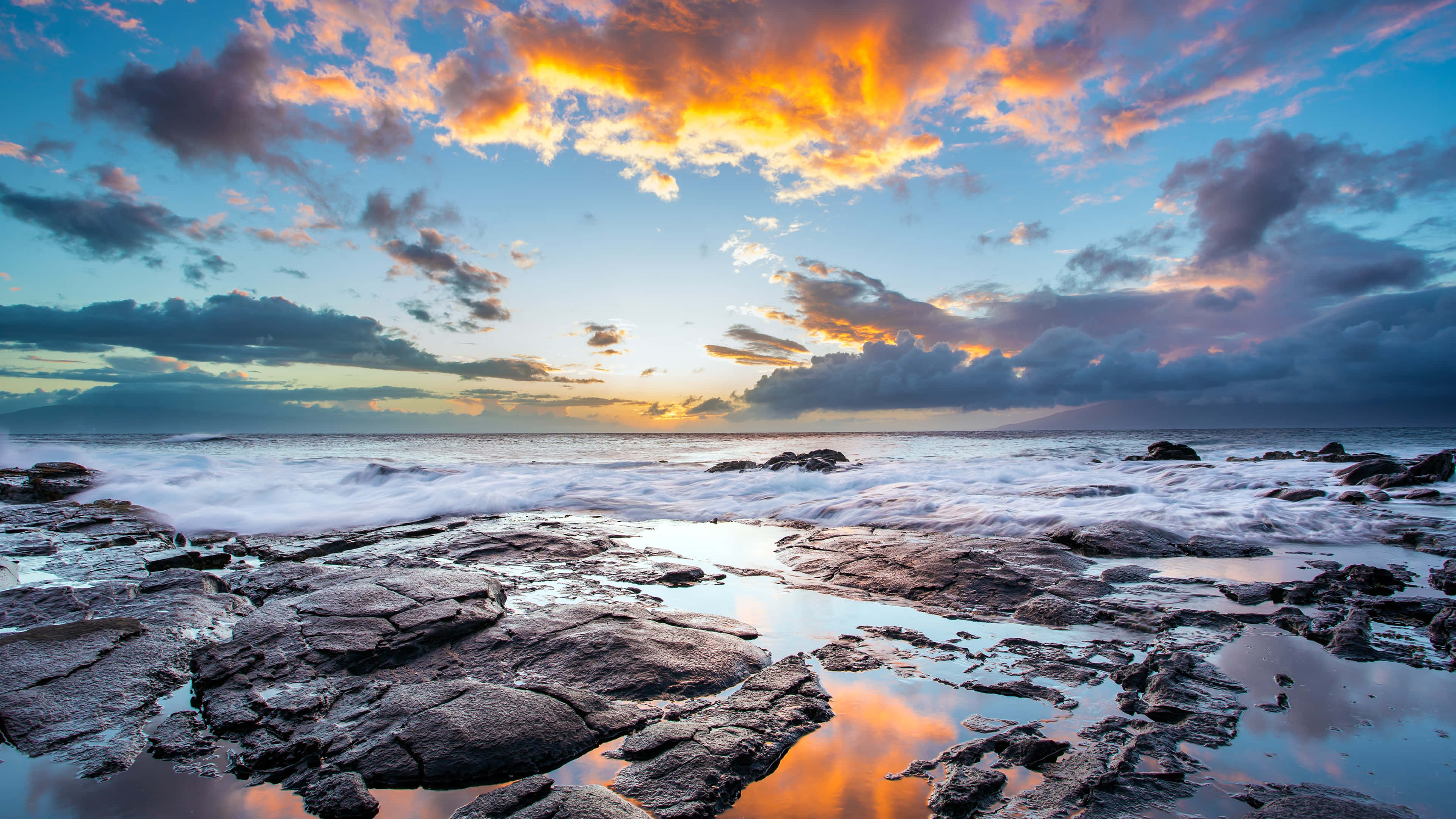 Beach Photography 桌布 壁紙 — 夕陽將天空染成火熱的橙色和紫色，海浪拍打崎嶇的海岸岩石。