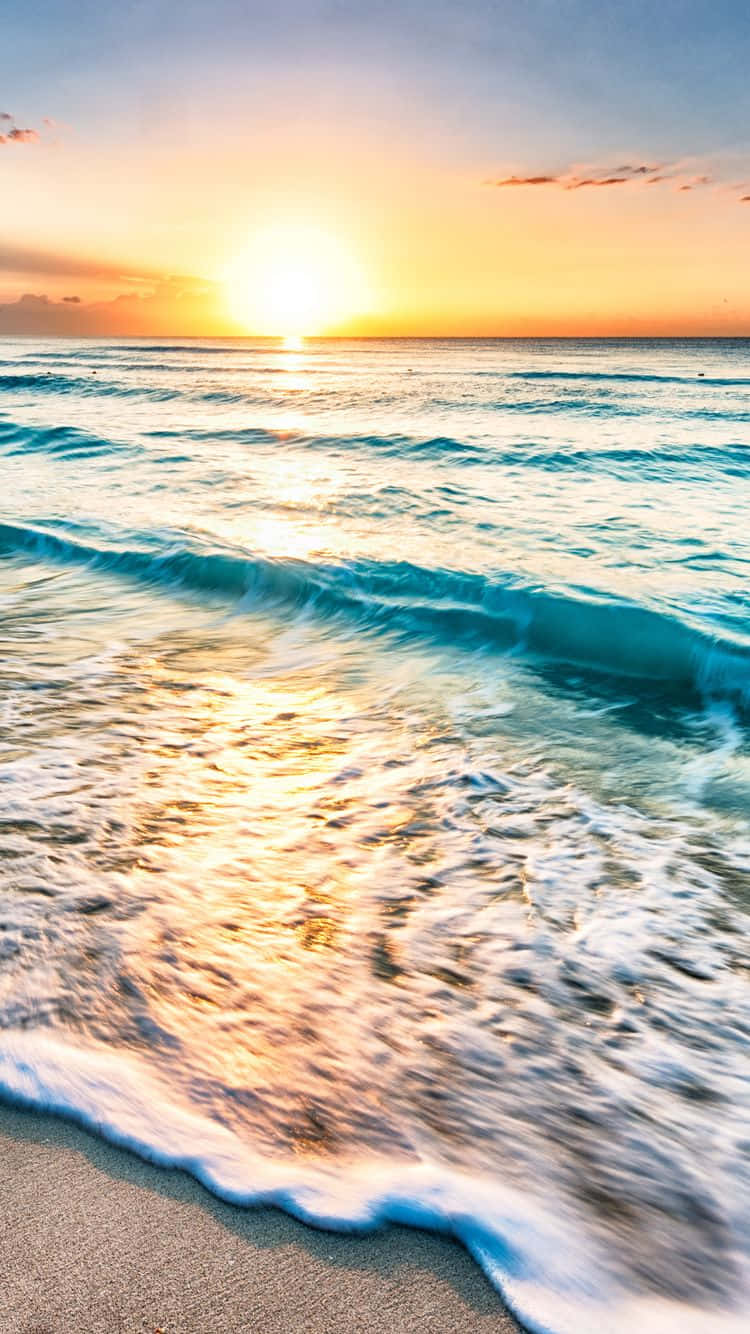 Yellow Beach 桌布 壁紙 — 夕陽將海洋染成金色調，波浪在柔和暮色天空下拍打沙灘。