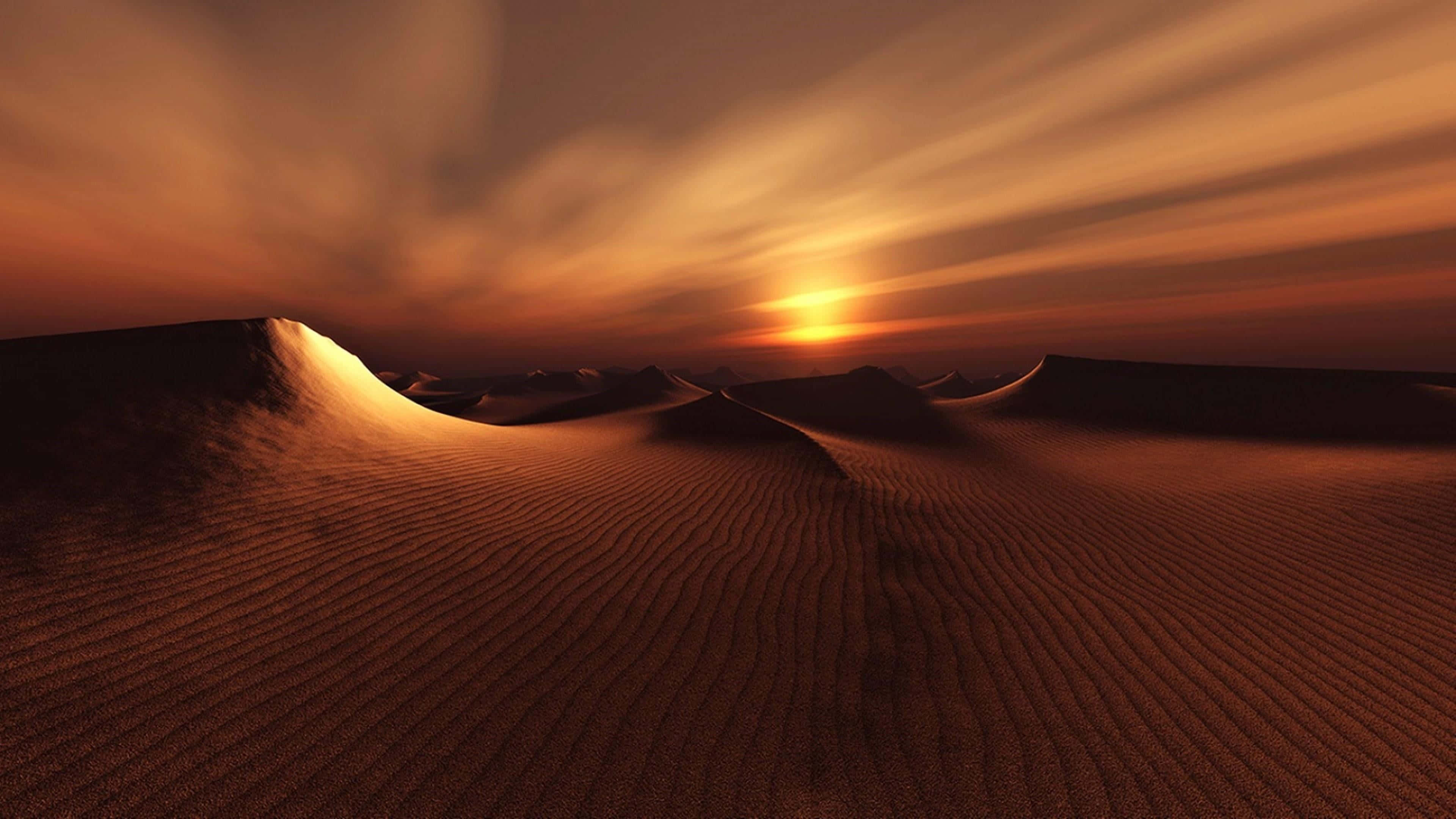 Sand Dunes 桌布 壁紙 — 夕陽將金色光芒灑在起伏的沙丘上，天空呈現條紋狀的橙色。
