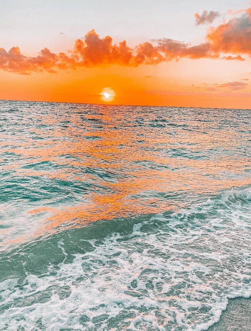 夕陽映照海面，海浪翻湧 壁紙
