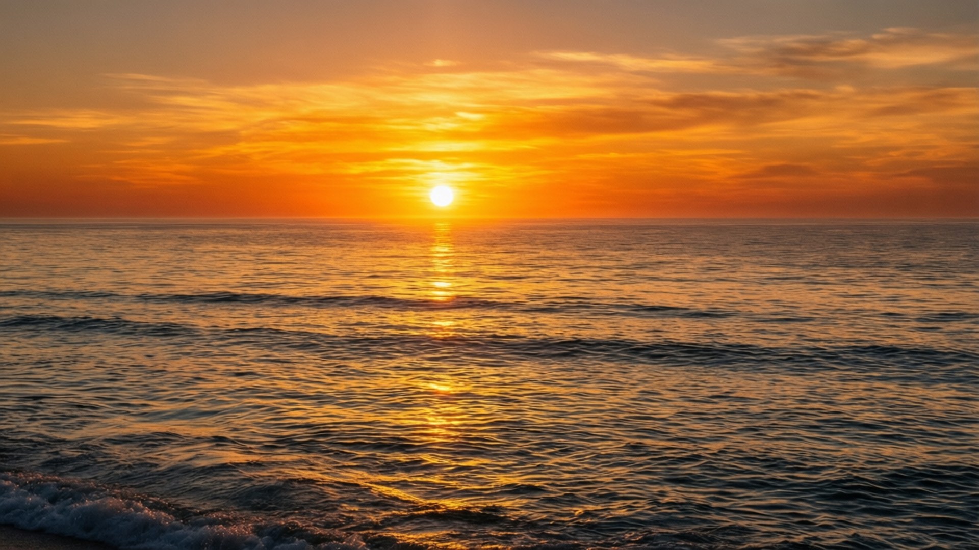 夕陽海灘寧靜光景 壁紙 — 一輪充滿活力的橙色夕陽在平靜的海面上落下，在溫柔的波浪上投下金色的倒影。