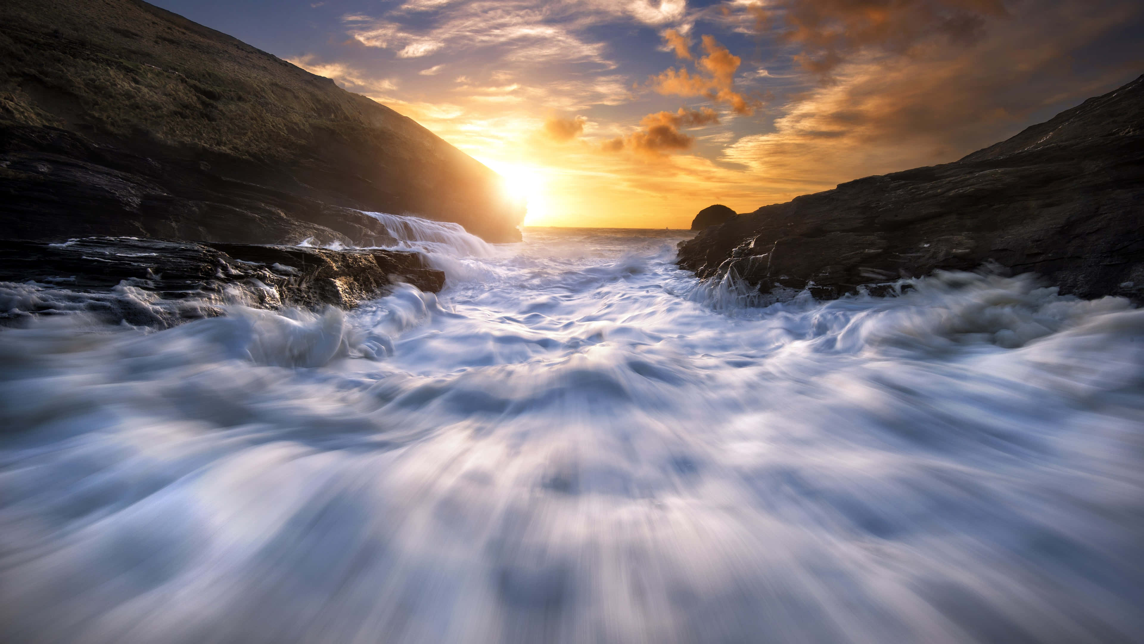 Tides 桌布 壁紙 — 夕陽照亮了黑暗懸崖之間拍打的海浪，長曝光海景。
