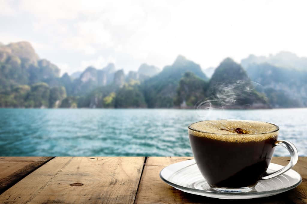木桌上的熱咖啡，可欣賞山景和水景