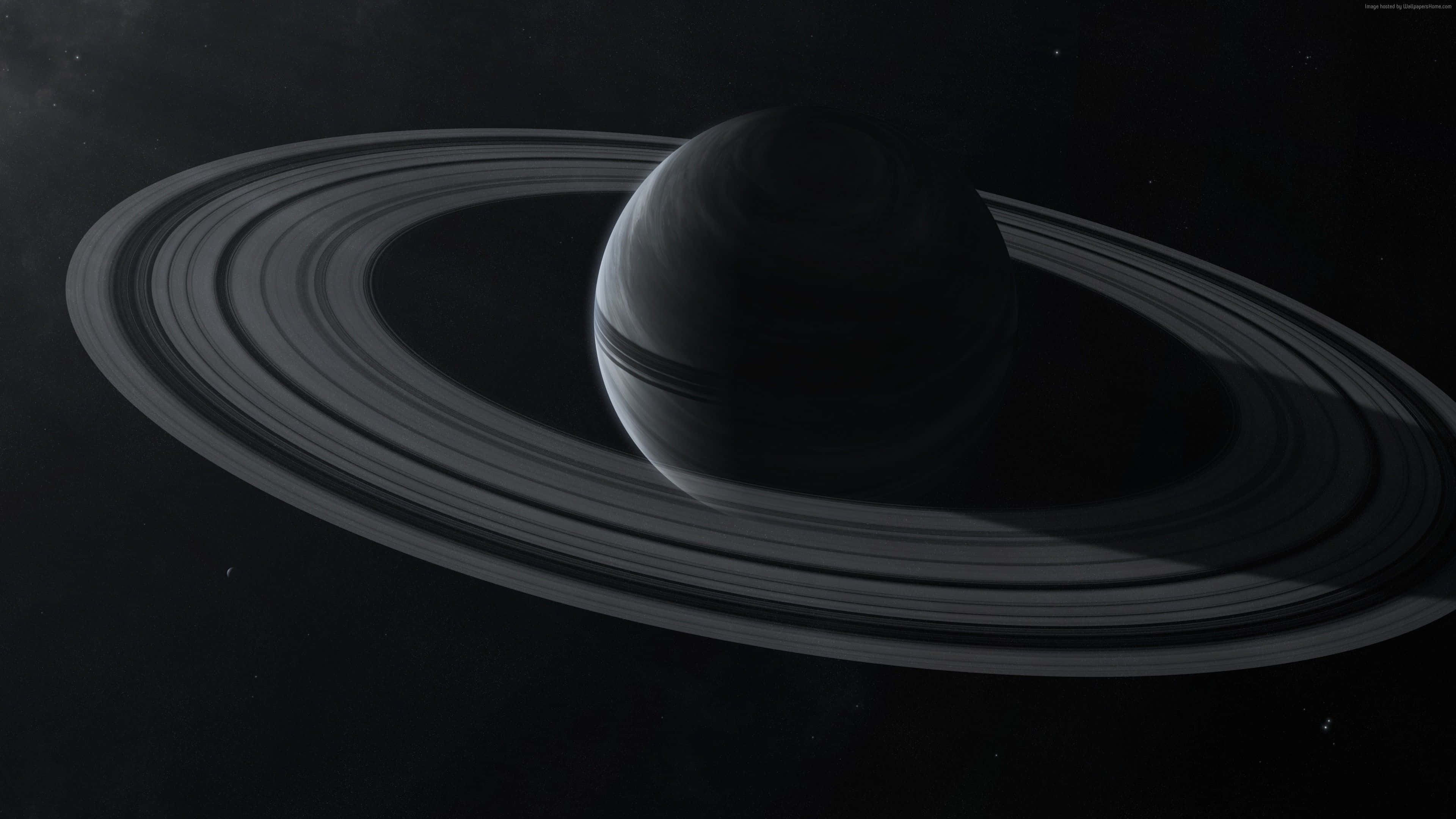 外星行星的壯麗景色 壁紙 — 土星的單色視圖，其標誌性光環在太空的虛空中柔和發光。