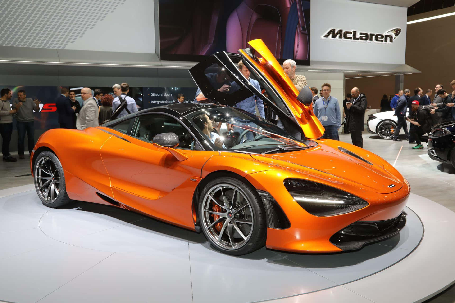 橙色McLaren跑車，鷗翼門打開，在車展上展出。