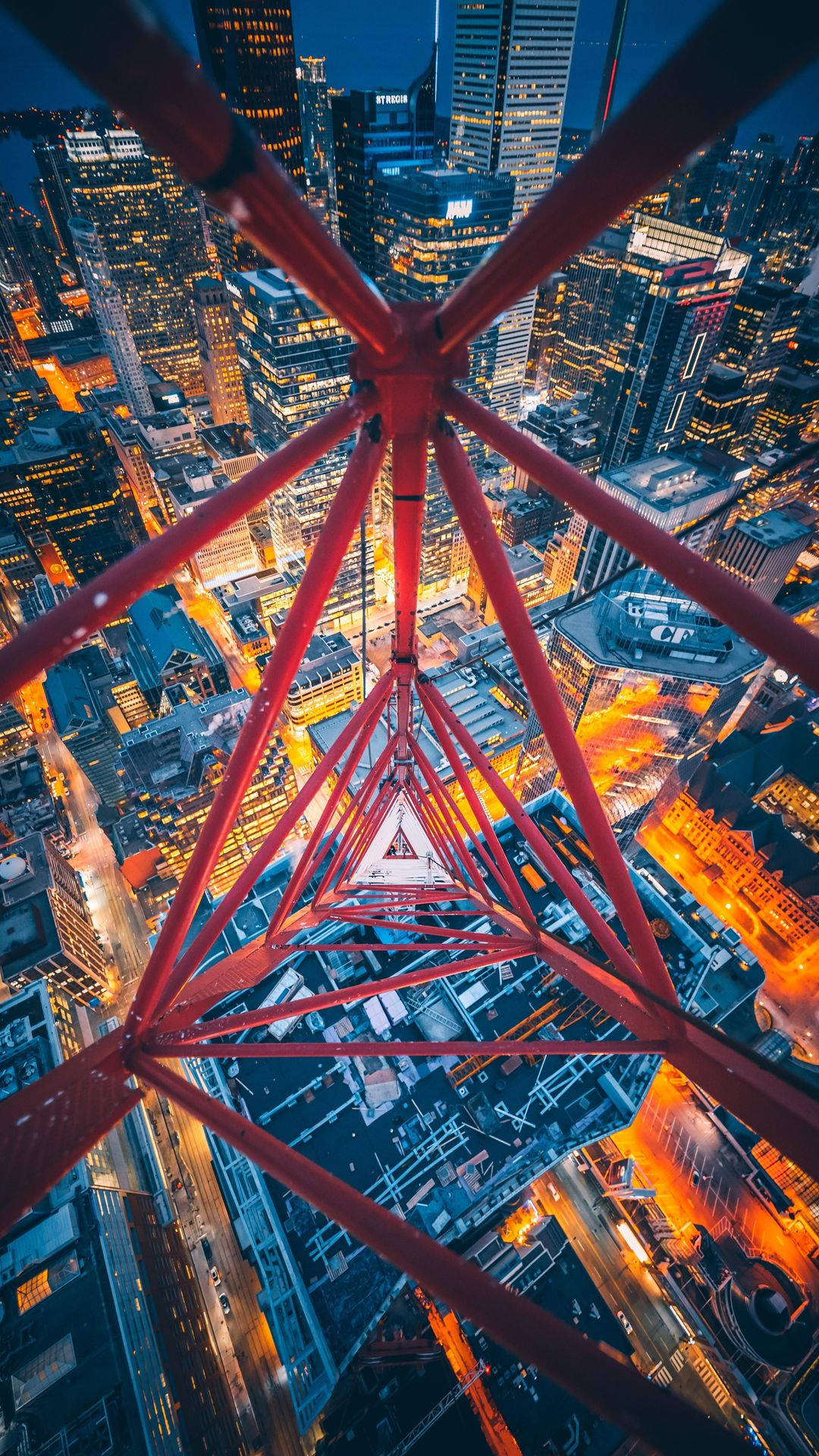 紅色鋼製格子塔俯瞰充滿活力的夜景，建築物和街道閃閃發光。