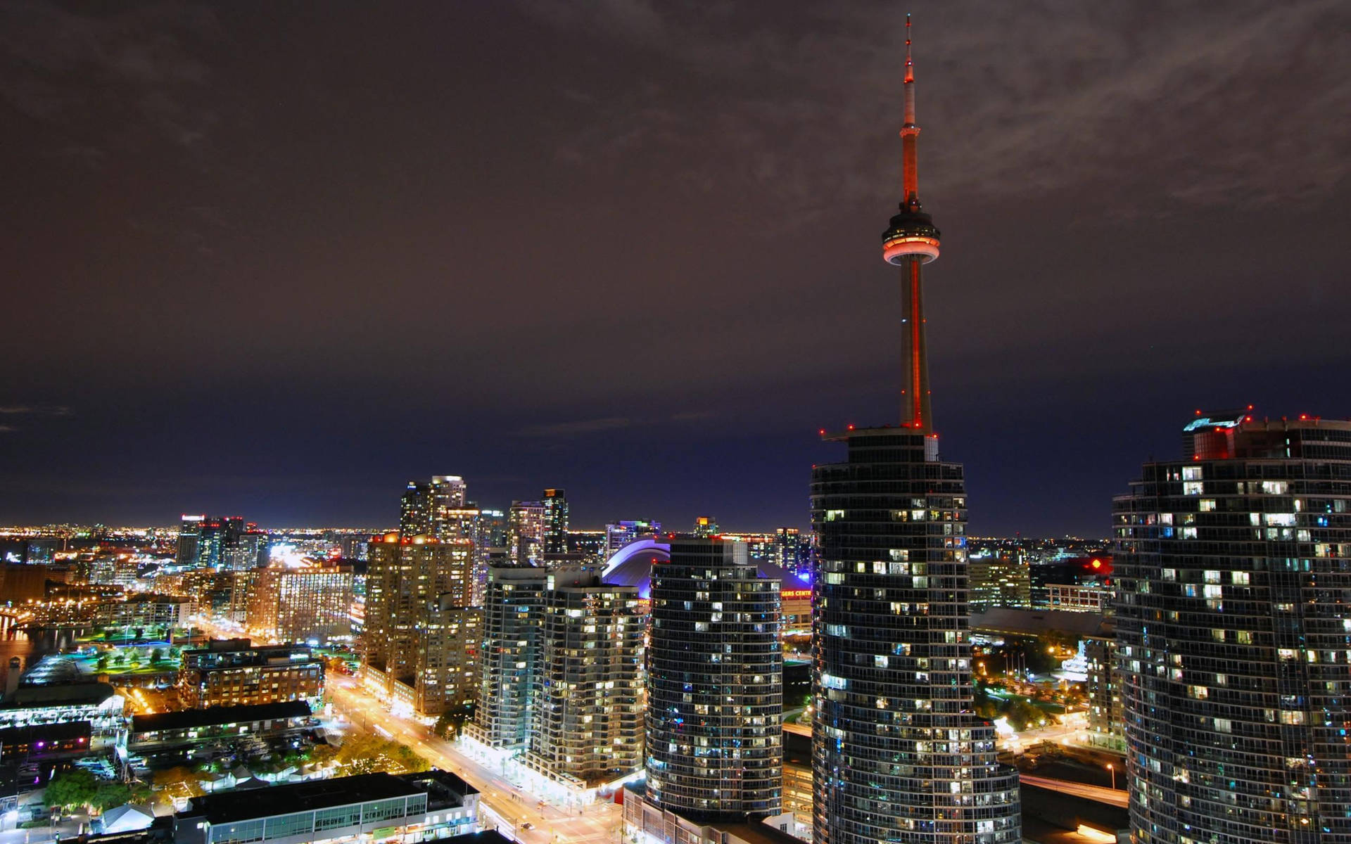 多倫多天際線夜景，CN塔亮起，周圍建築物閃爍。