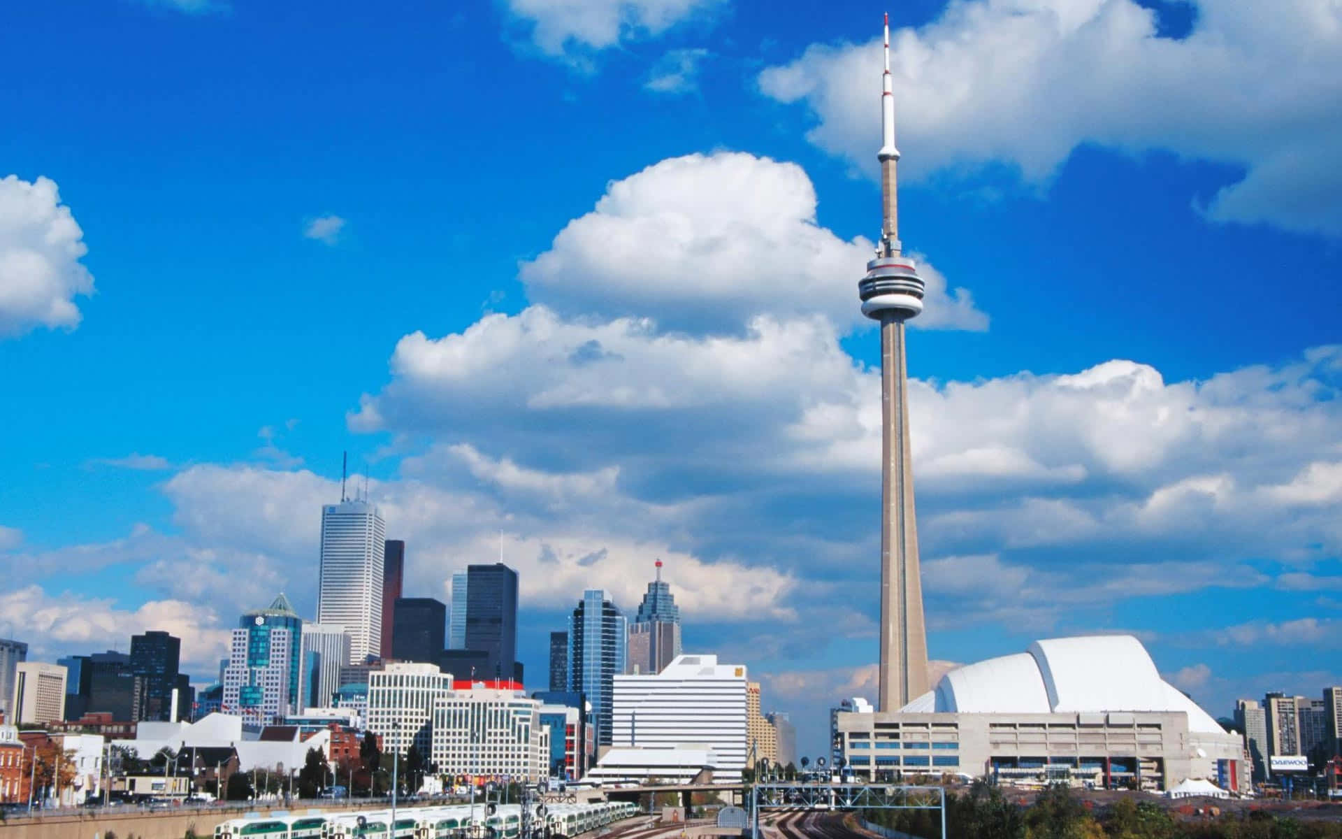 Toronto 桌布 壁紙 — 多倫多天際線，CN塔刺穿點綴著蓬鬆白雲的明亮藍天。