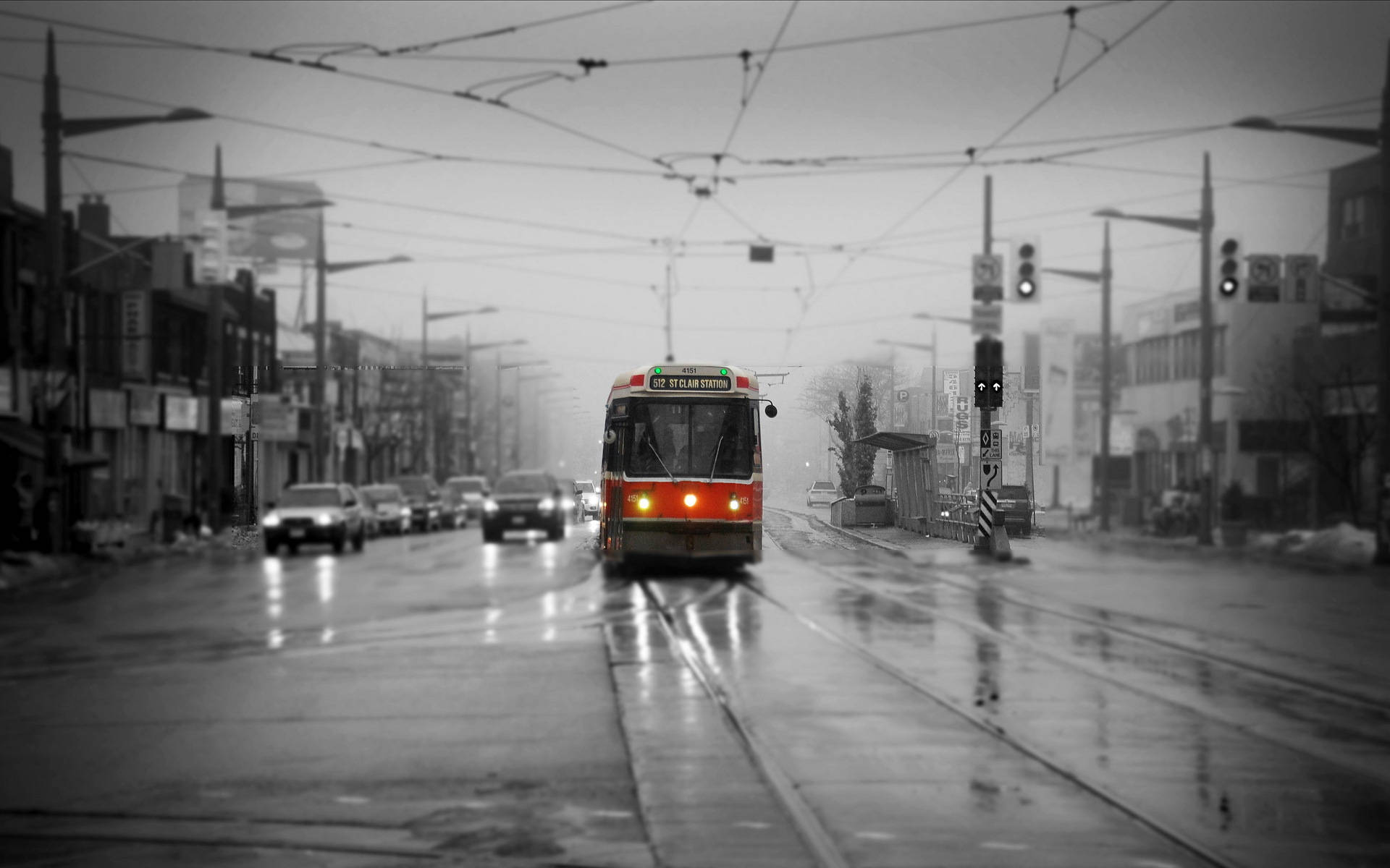 紅色電車在潮濕的街道上行駛，路面濕滑，汽車模糊。