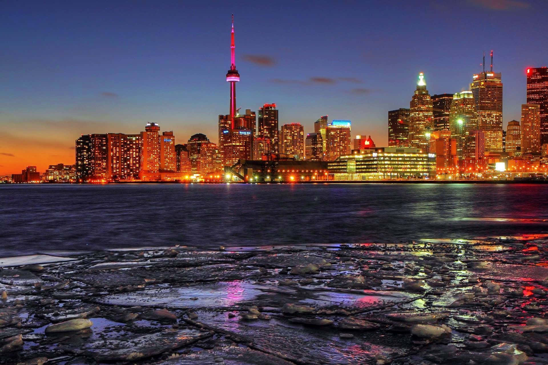 Toronto 桌布 壁紙 — 多倫多黃昏天際線，前景冰凍水面反射出燈火通明的摩天大樓。