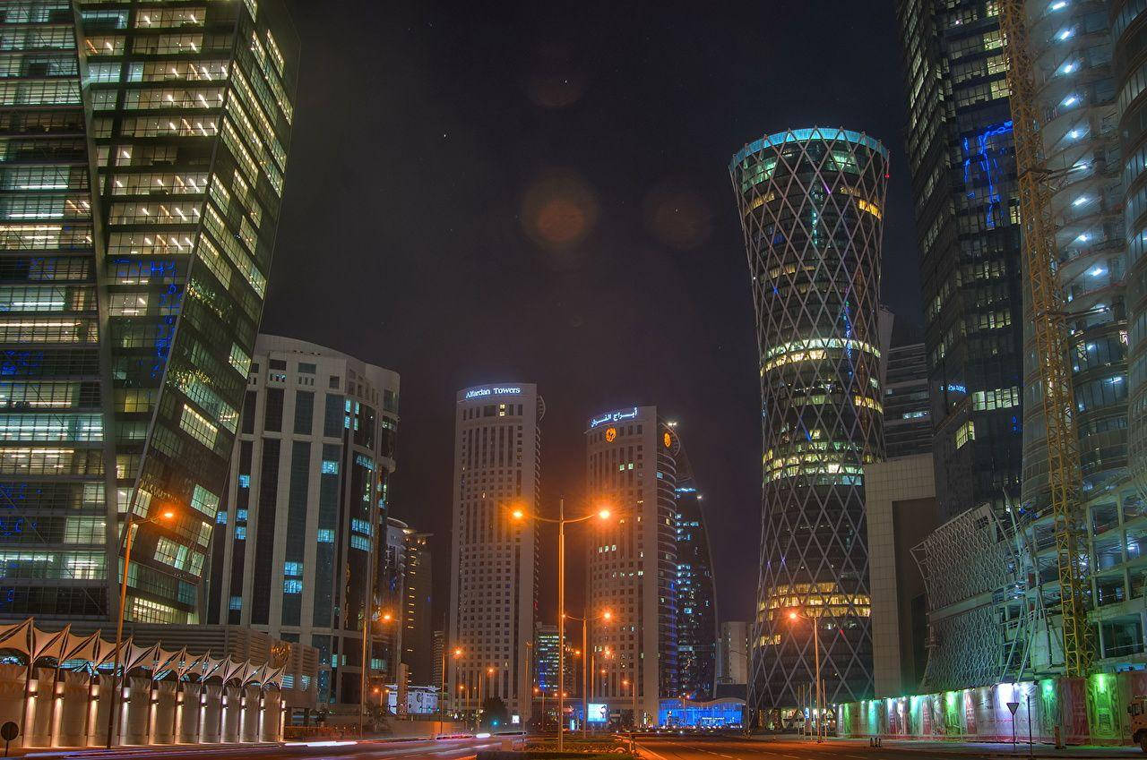 夜晚的城市景觀，有燈火通明的摩天大樓和街燈。