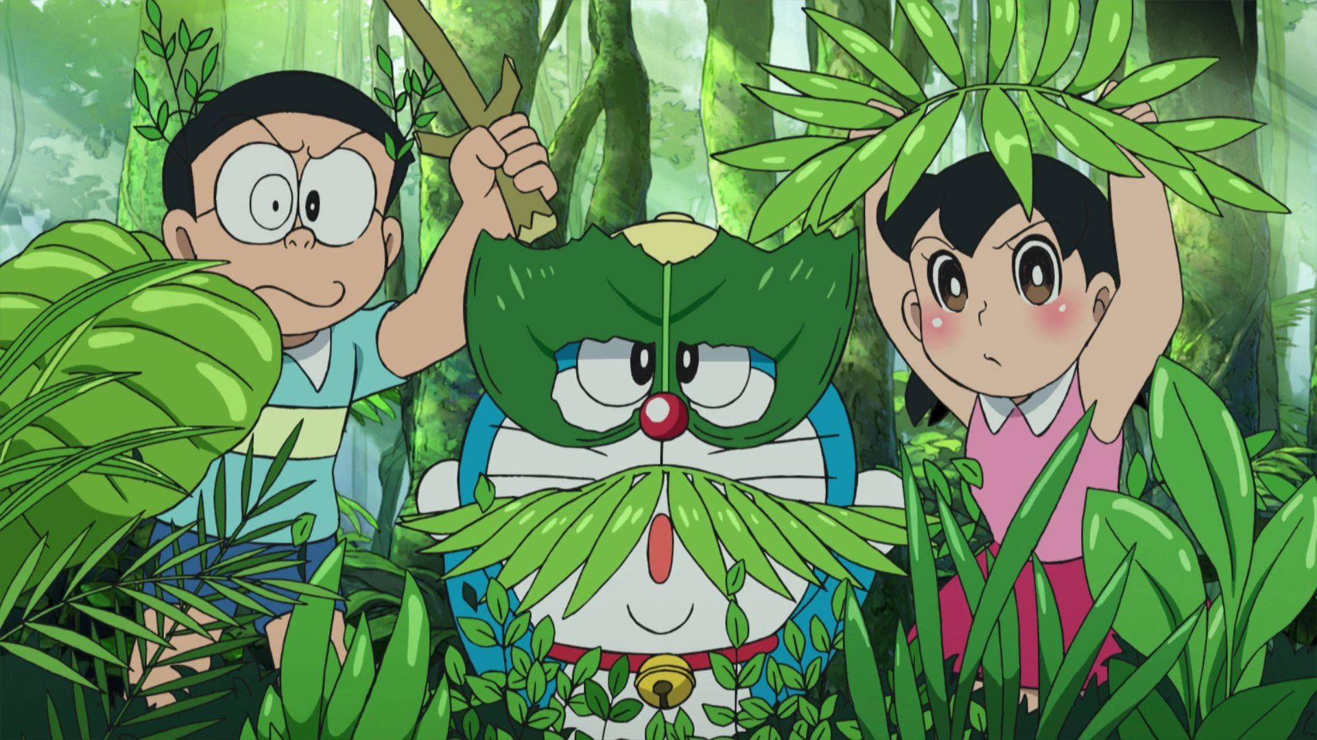 Doraemon 桌布 壁紙 — 多啦A夢、大雄和靜香在茂密的綠色叢林中用樹葉作偽裝，手持樹枝躲藏。