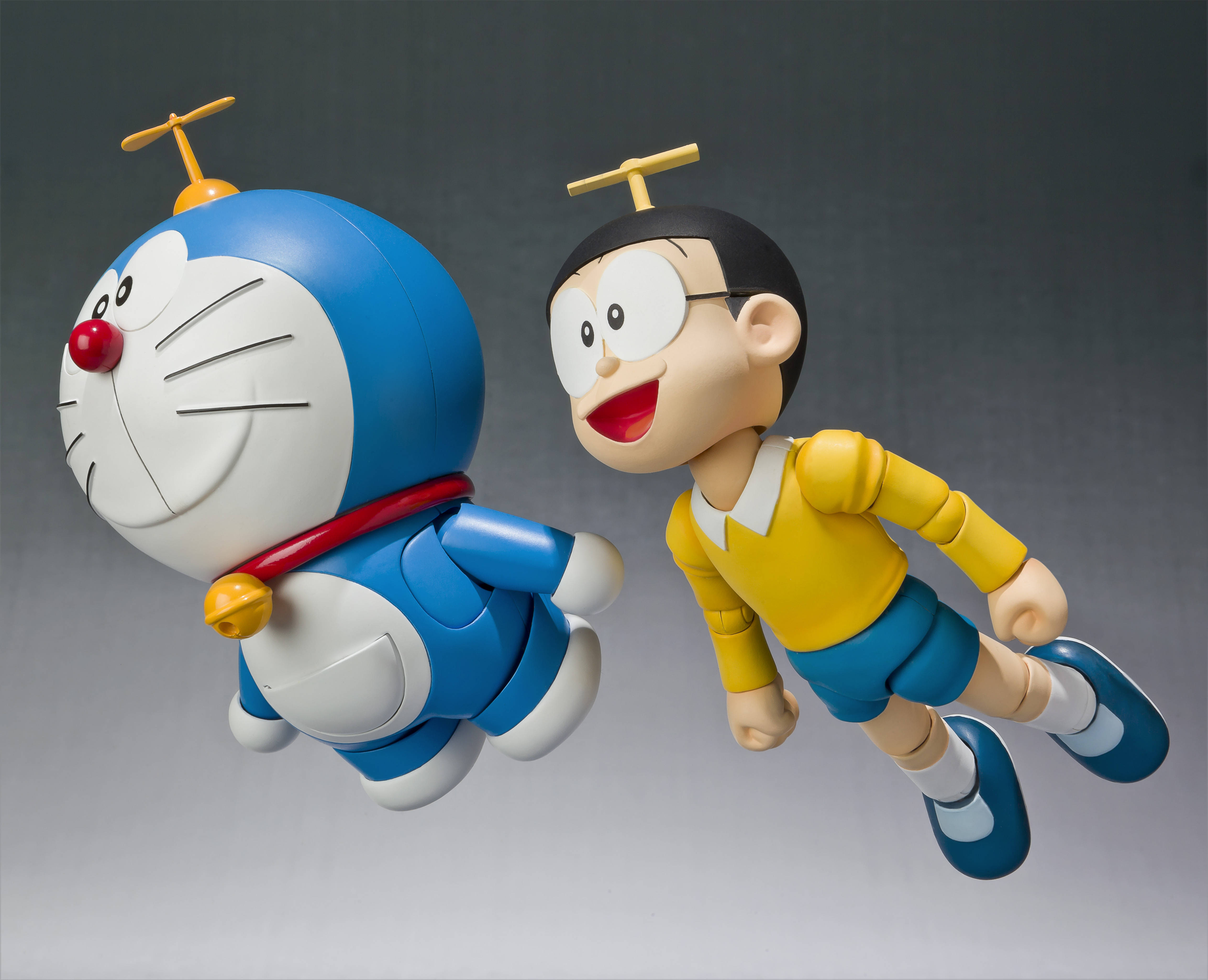 Doraemon 桌布 壁紙 — 多啦A夢和大雄頭頂小型直升機螺旋槳，帶著愉快表情在空中飛翔。