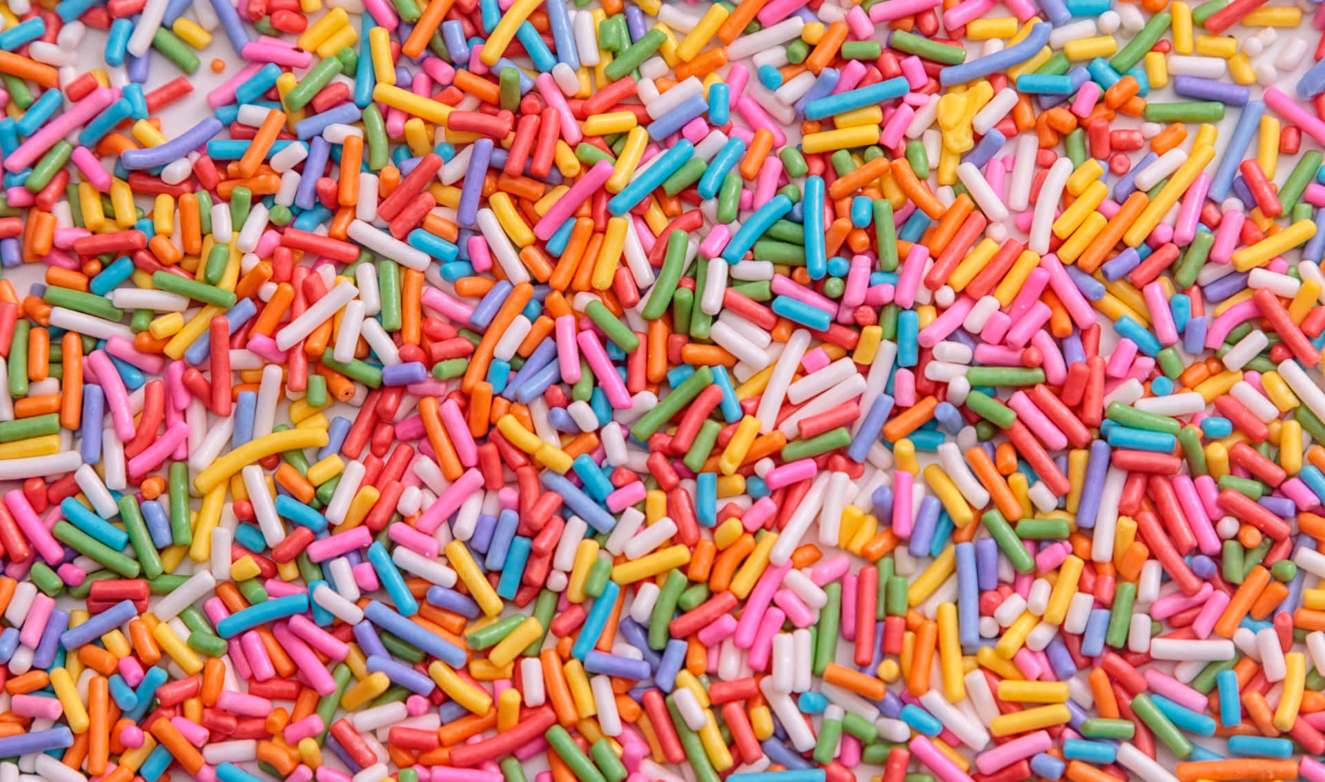 白色表面上色彩繽紛的糖粒排列。