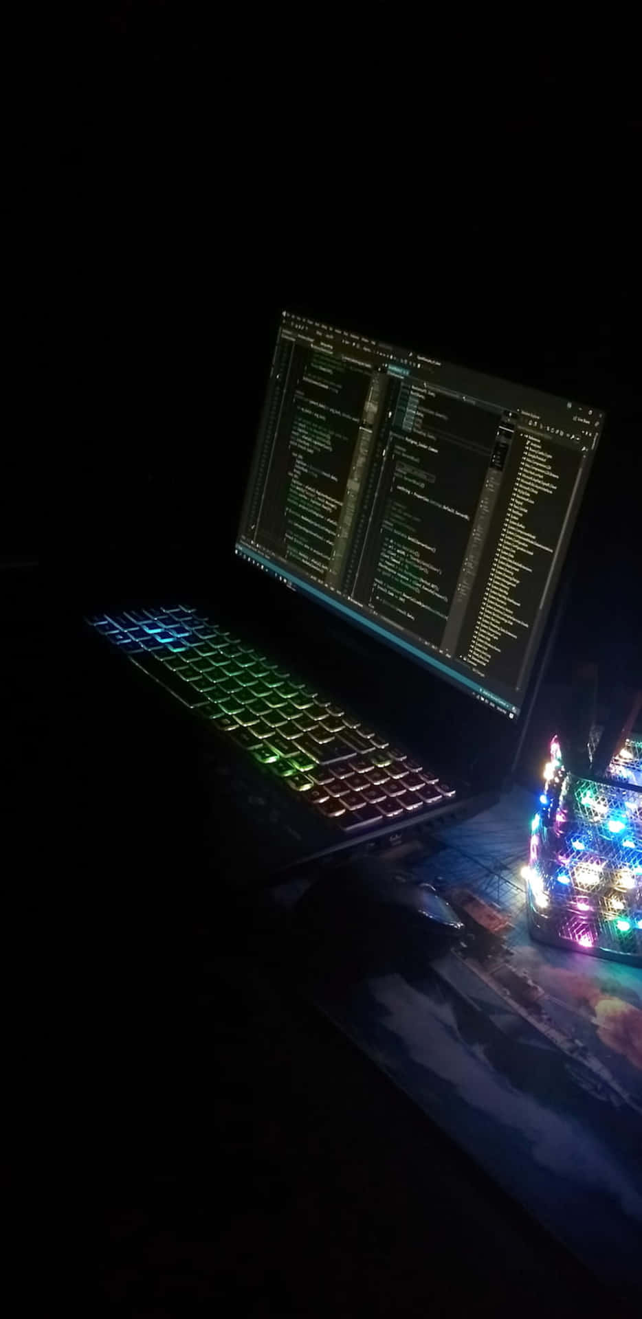 筆記本電腦配備彩虹鍵盤和代碼顯示，旁邊是發光LED裝置。
