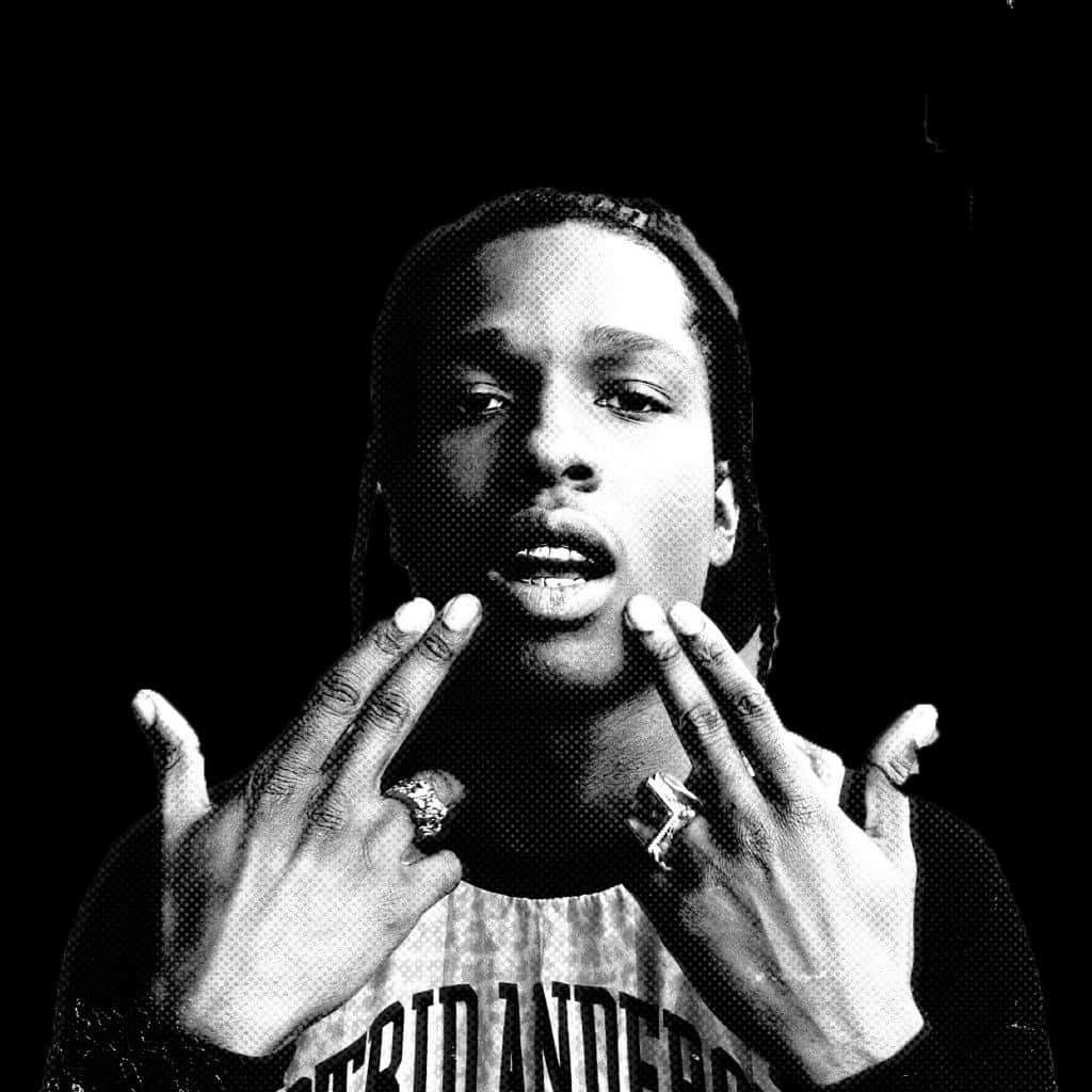 多才多藝的 ASAP Rocky 舞台演出 壁紙 — 一張黑白半色調人像，人物雙手靠近臉部，戴著戒指，背景深色。
