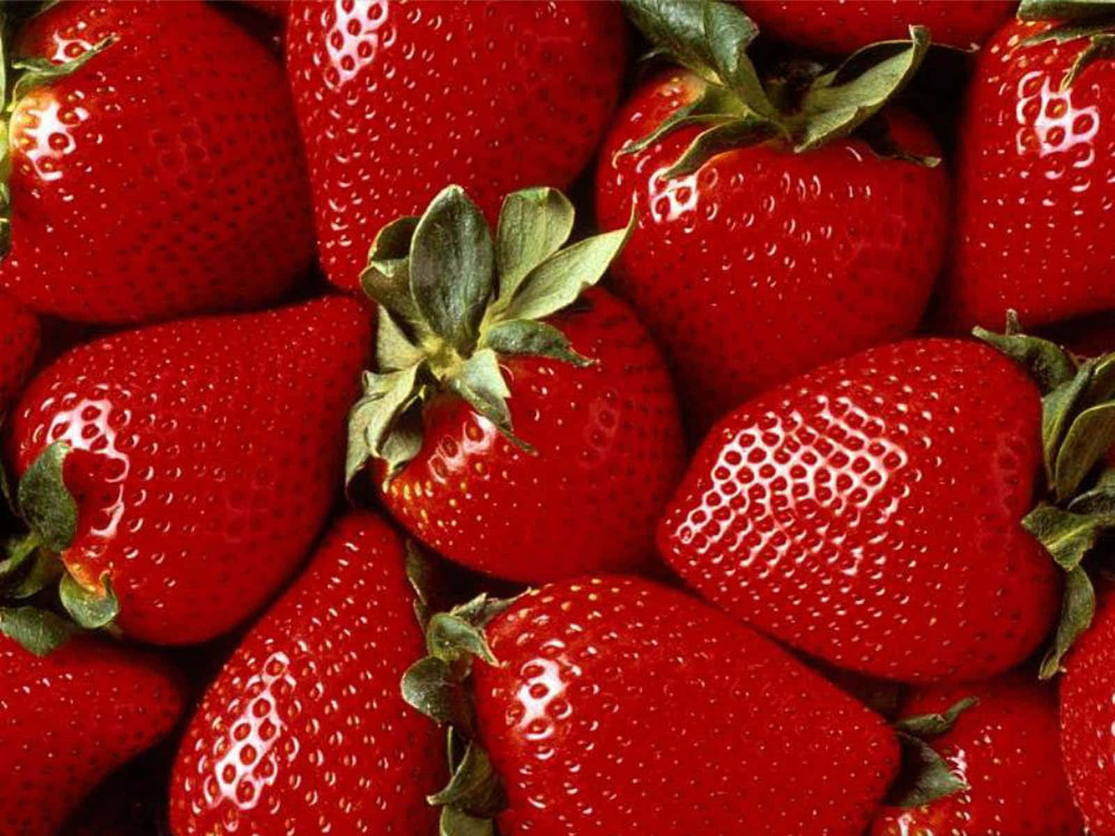Cute Strawberry 桌布 壁紙 — 多汁成熟的草莓帶有綠色蒂頭，在特寫鏡頭下於明亮光線中閃閃發光。