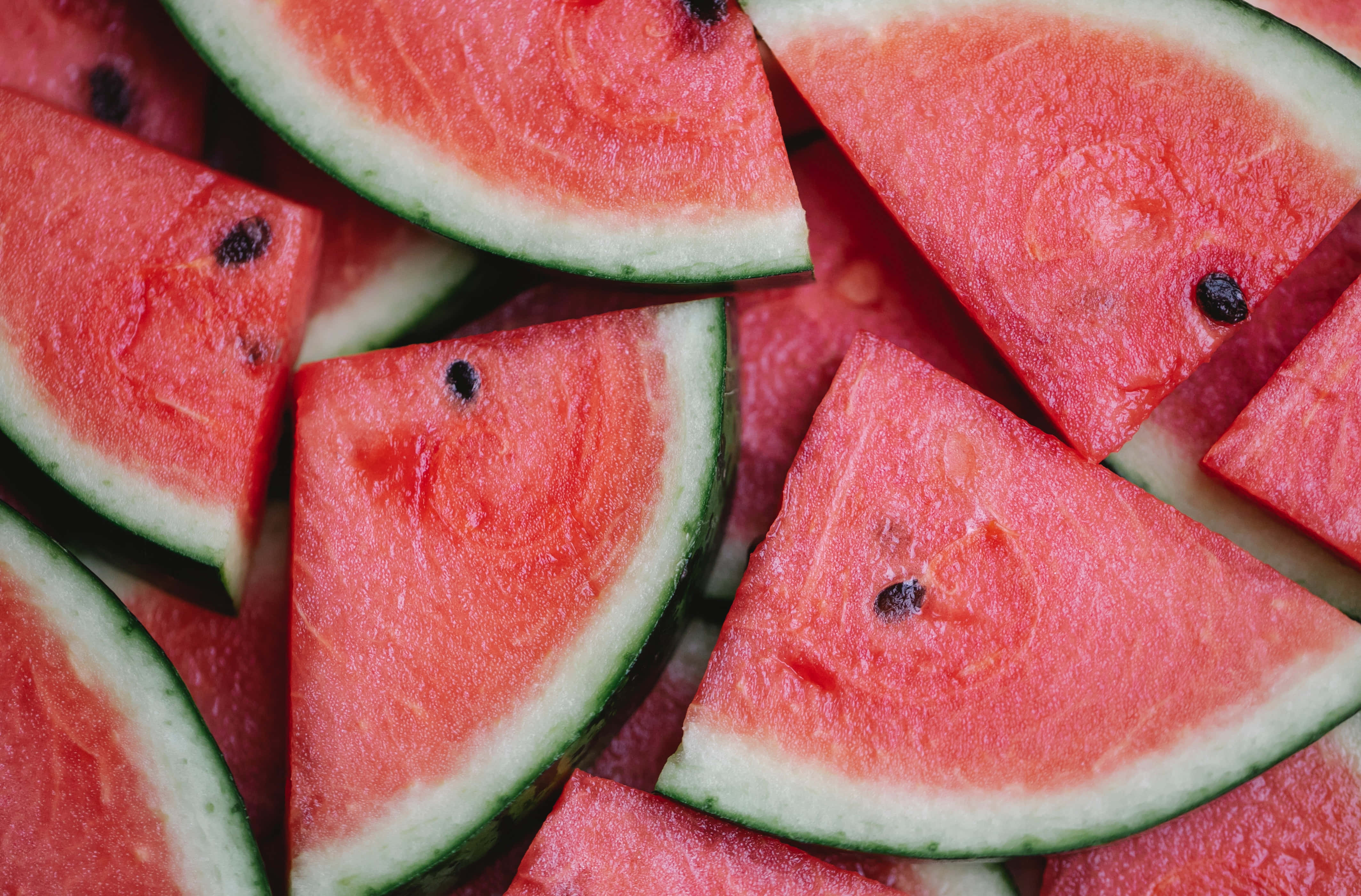 Summer Fruits 桌布 壁紙 — 多汁西瓜片，帶有鮮紅色果肉和深色種子，以俯拍特寫方式排列。
