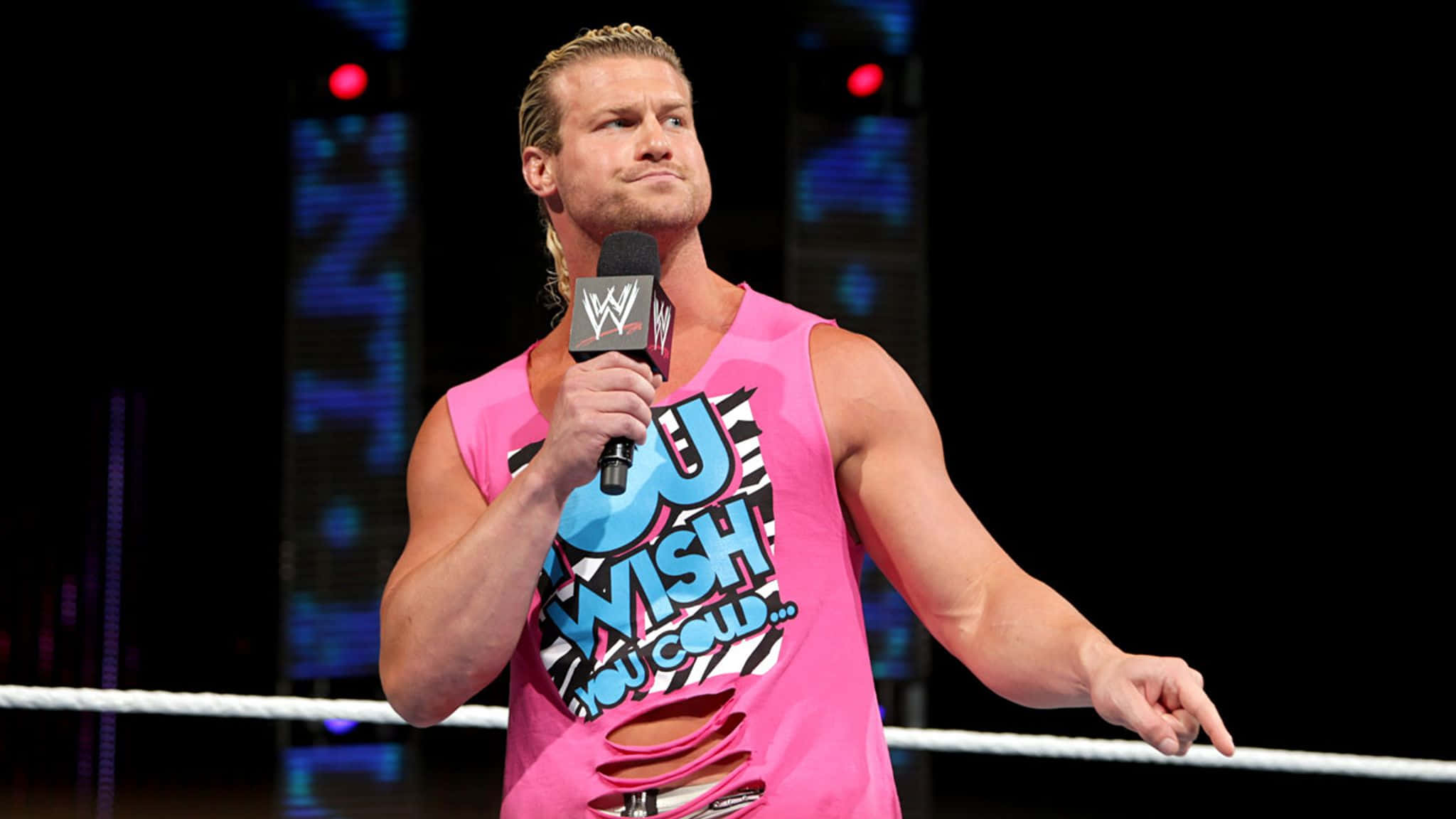 多獎項得主 Dolph Ziggler 壁紙 — WWE摔角手丹尼爾·布萊恩站在擂台上，手持麥克風，身穿一件亮粉紅色破洞背心，上面有粗體文字。