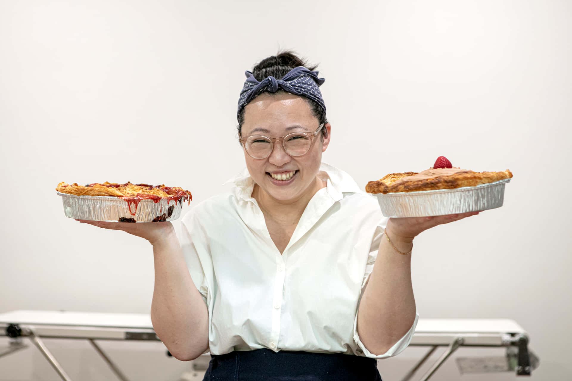 女士捧著兩個餡餅，笑容燦爛