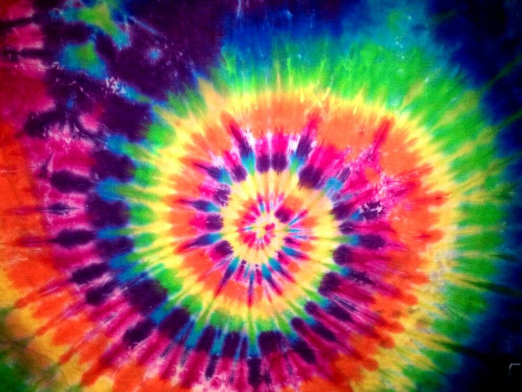 色彩繽紛的紮染螺旋圖案，帶有彩虹色調和深紫色邊緣。