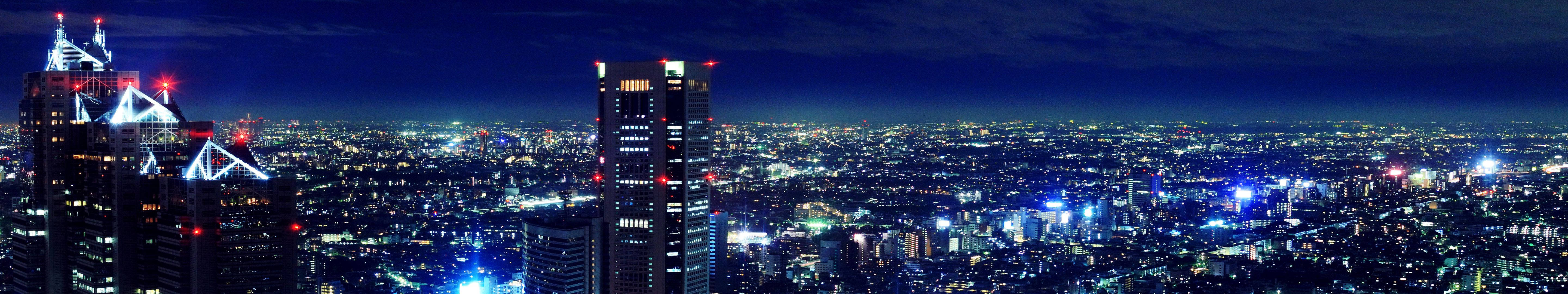 夜間充滿活力的城市天際線，燈火通明的摩天大樓和密集的城市燈光。