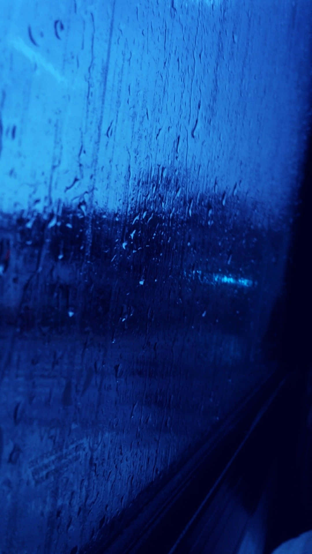 夜間車窗上的雨滴，背景是模糊的城市燈光。
