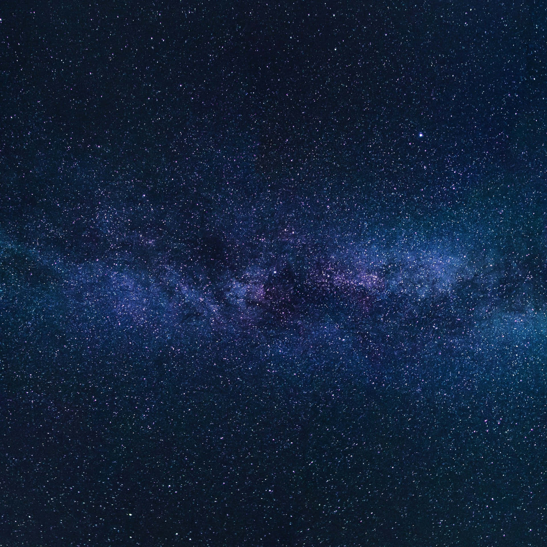 銀河系在漆黑的夜空中散發著紫色和藍色的星光。