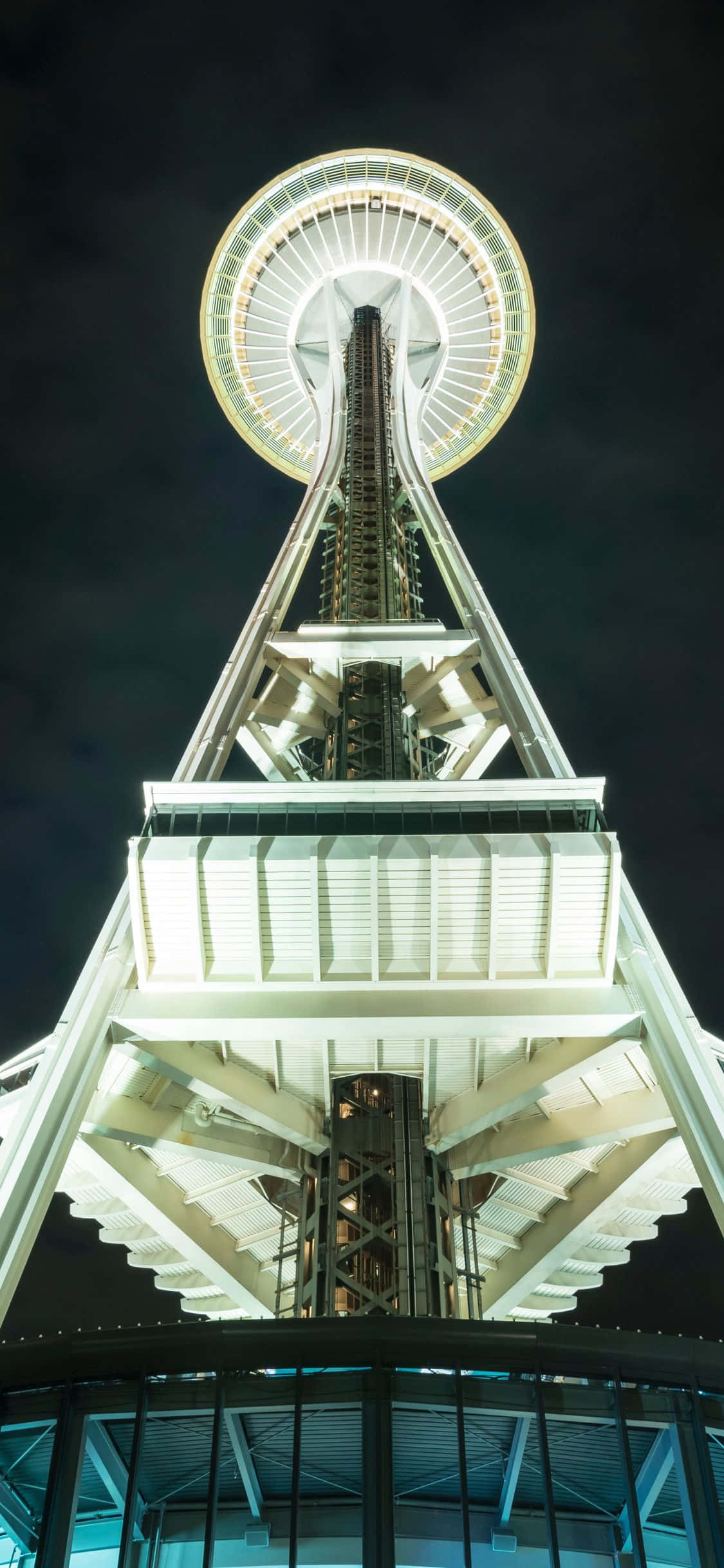 夜幕下的西雅圖天際線 壁紙 — 西雅圖太空針塔在黑暗天空中發光的戲劇性低角度夜間照片。