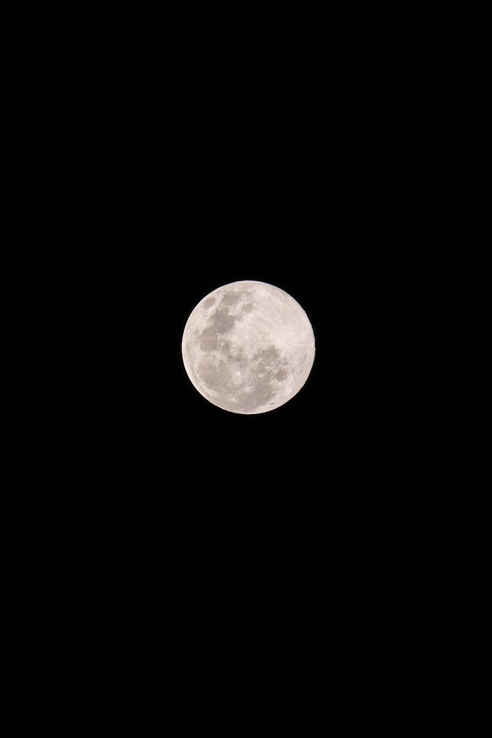夜幕城市燈光璀璨高清全屏壁紙 壁紙 — 一輪滿月，可見隕石坑和月海，在漆黑的夜空中柔和地發光。