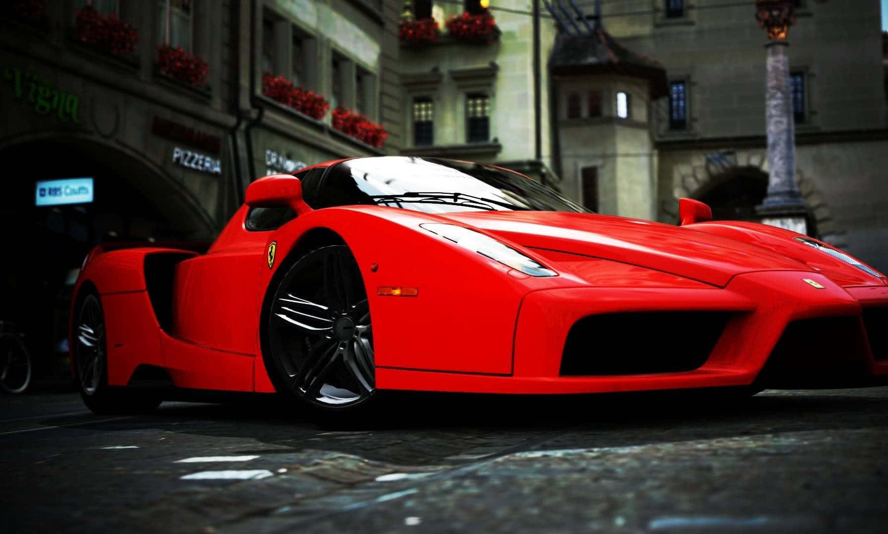 Ferrari Enzo 桌布 壁紙 — 夜晚，一輛鮮紅色法拉利Enzo停泊在歐洲薄餅店前的濕滑鵝卵石街道上。