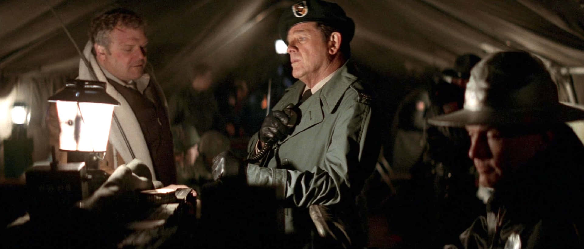 Richard Crenna 桌布 壁紙 — 夜晚，兩名身穿軍裝的男子在帆布帳篷內昏暗的燈光下交談。