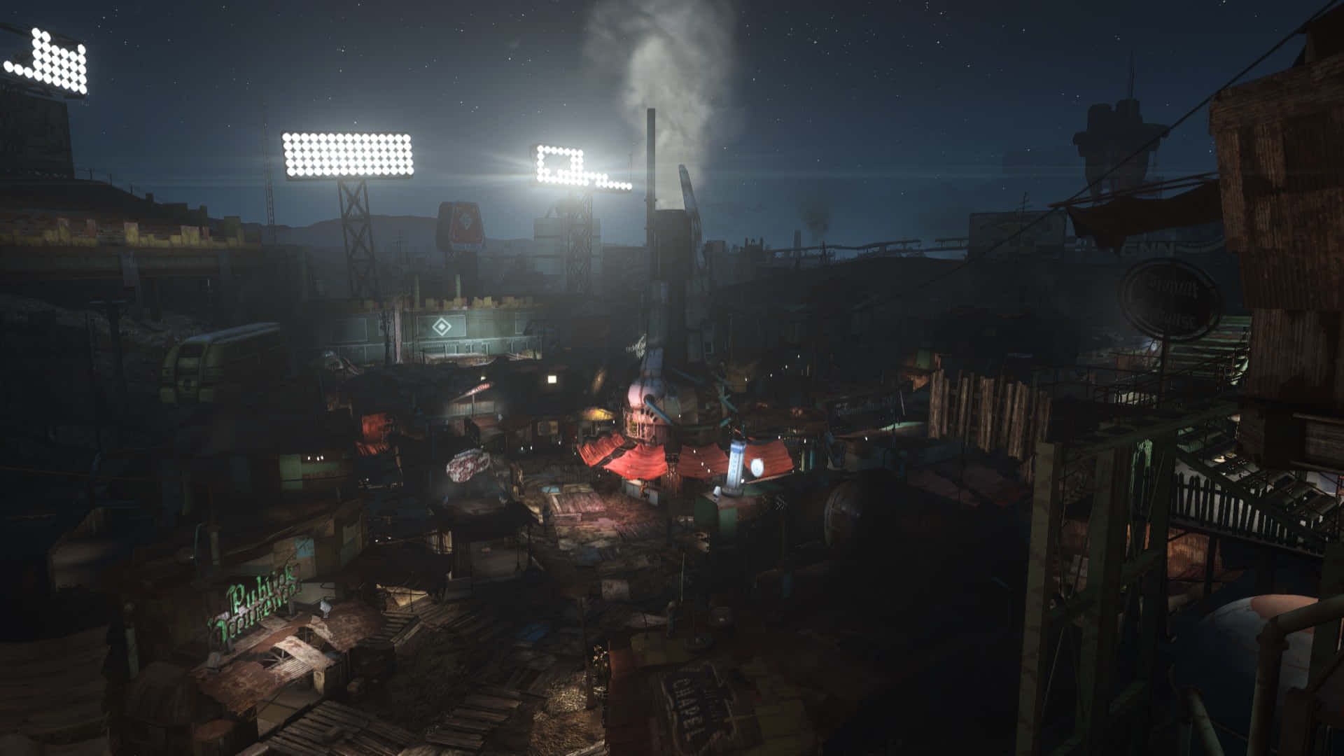 Diamond City 桌布 壁紙 — 夜晚一個粗糙的霓虹燈照亮工業廢墟，高聳的泛光燈和從腐朽建築物升起的煙霧。
