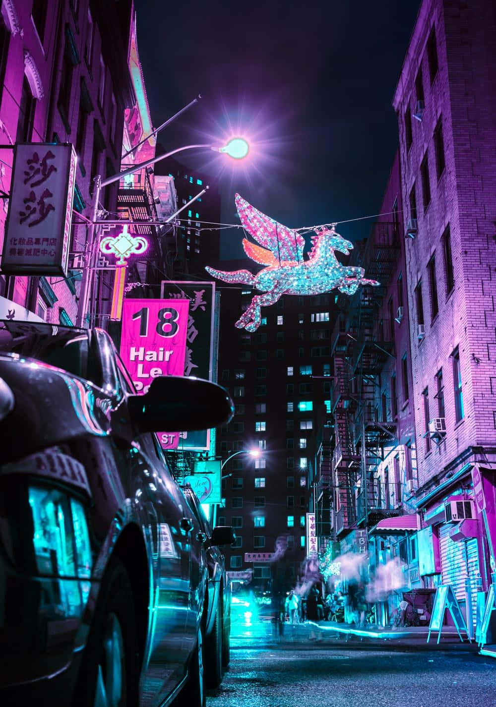 Galaxy Unicorn 桌布 壁紙 — 夜晚一條充滿霓虹燈的城市小巷，停泊的汽車和發光的商店櫥窗上方有一個發光的有翼馬標誌。