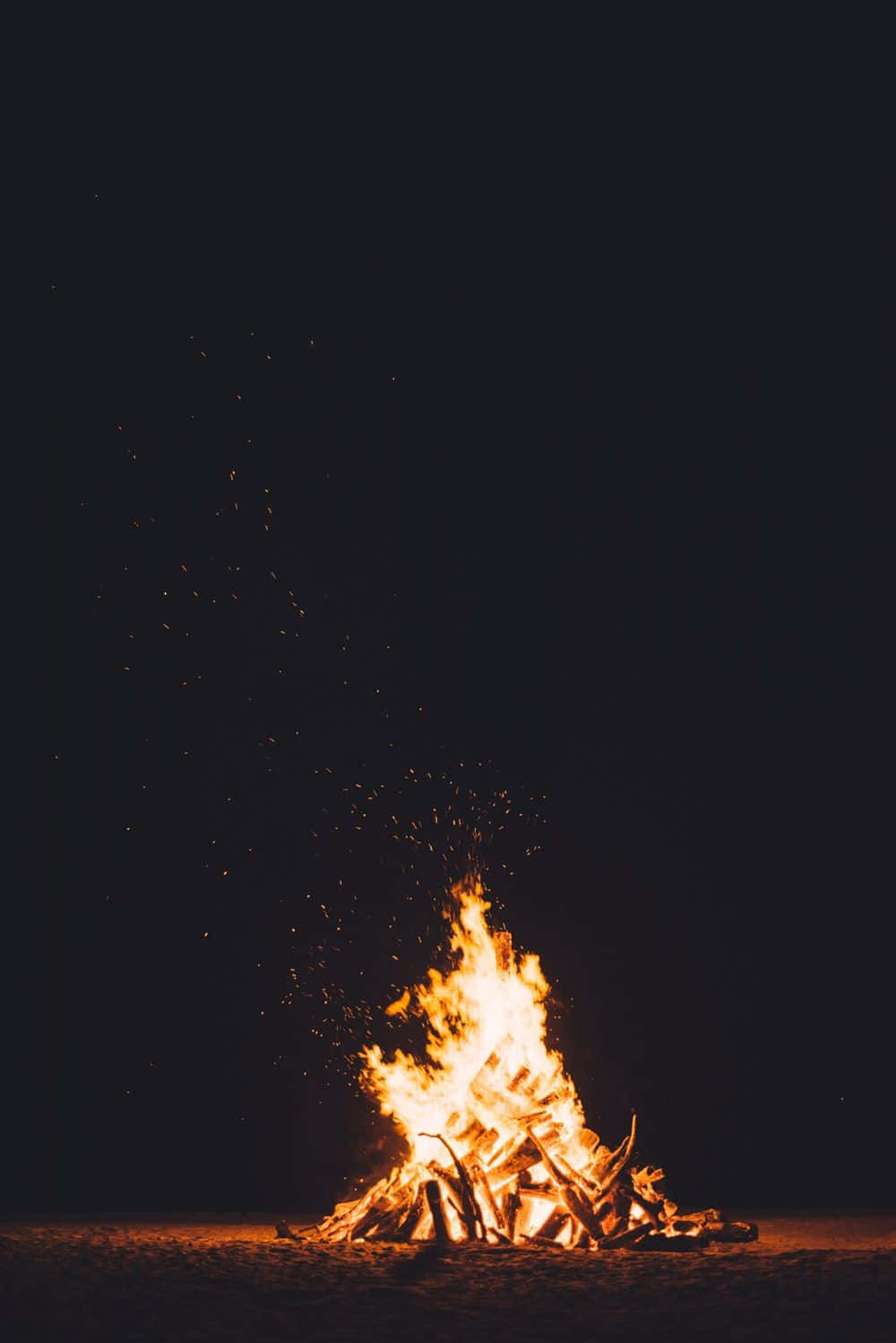 Burn 桌布 壁紙 — 夜晚咆哮的營火將明亮的橙色火焰和發光的餘燼在漆黑的天空中舞動。
