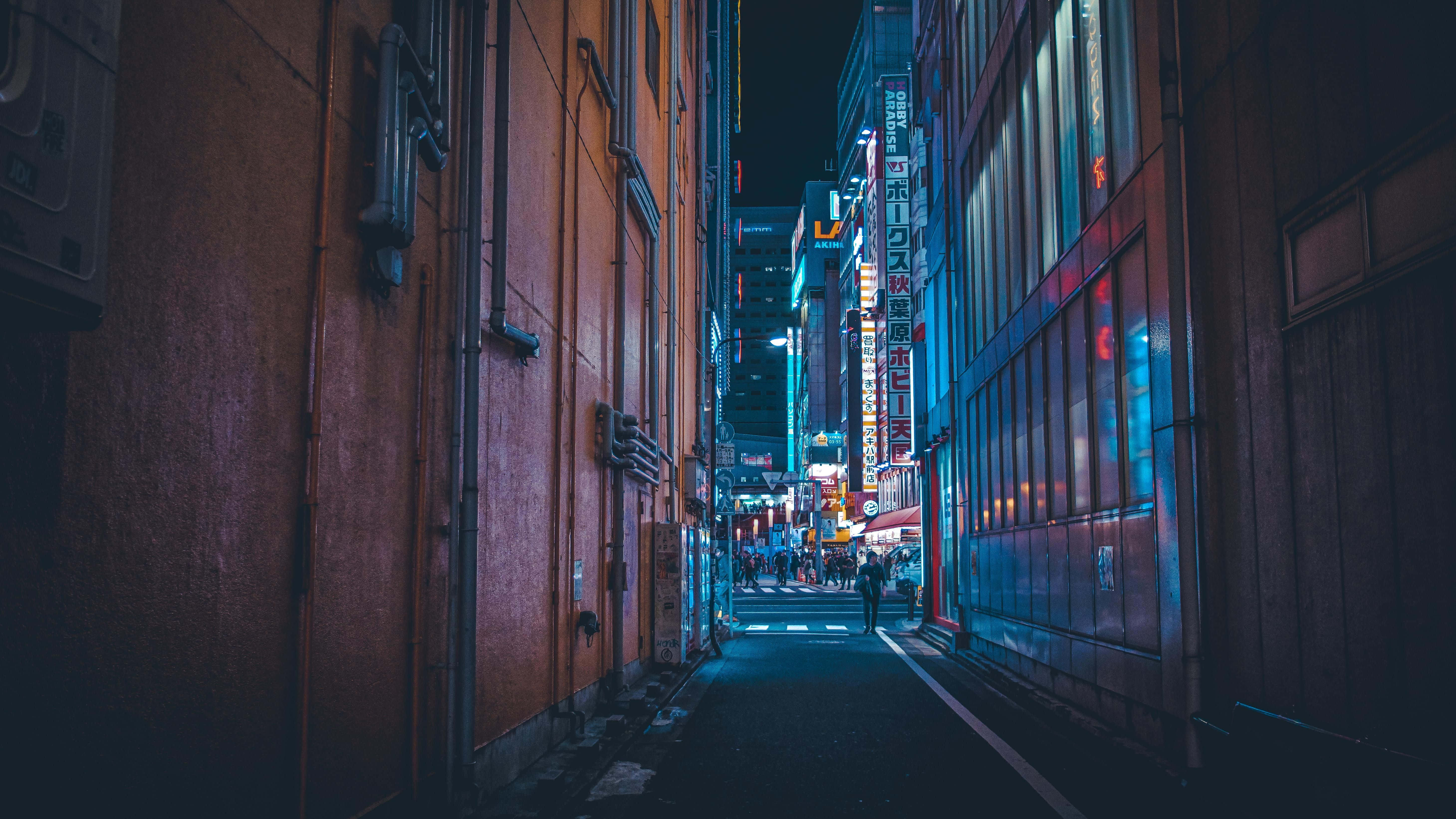 Alleyway 桌布 壁紙 — 夜晚在繁華的日本城市中一條狹窄的霓虹燈小巷，有發光的招牌和行人。